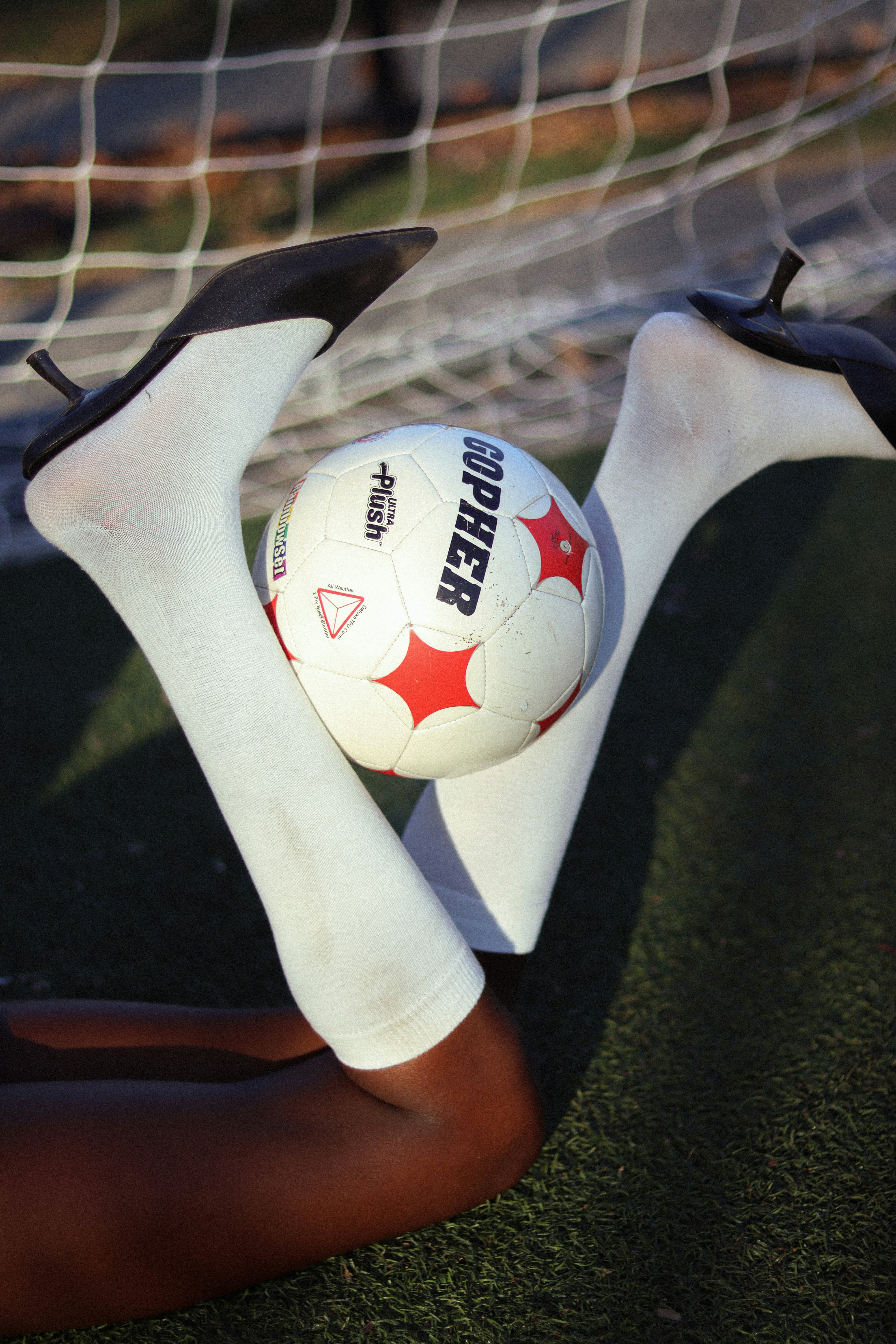 High heel on soccer ball high fashion sporty and rich aesthetic