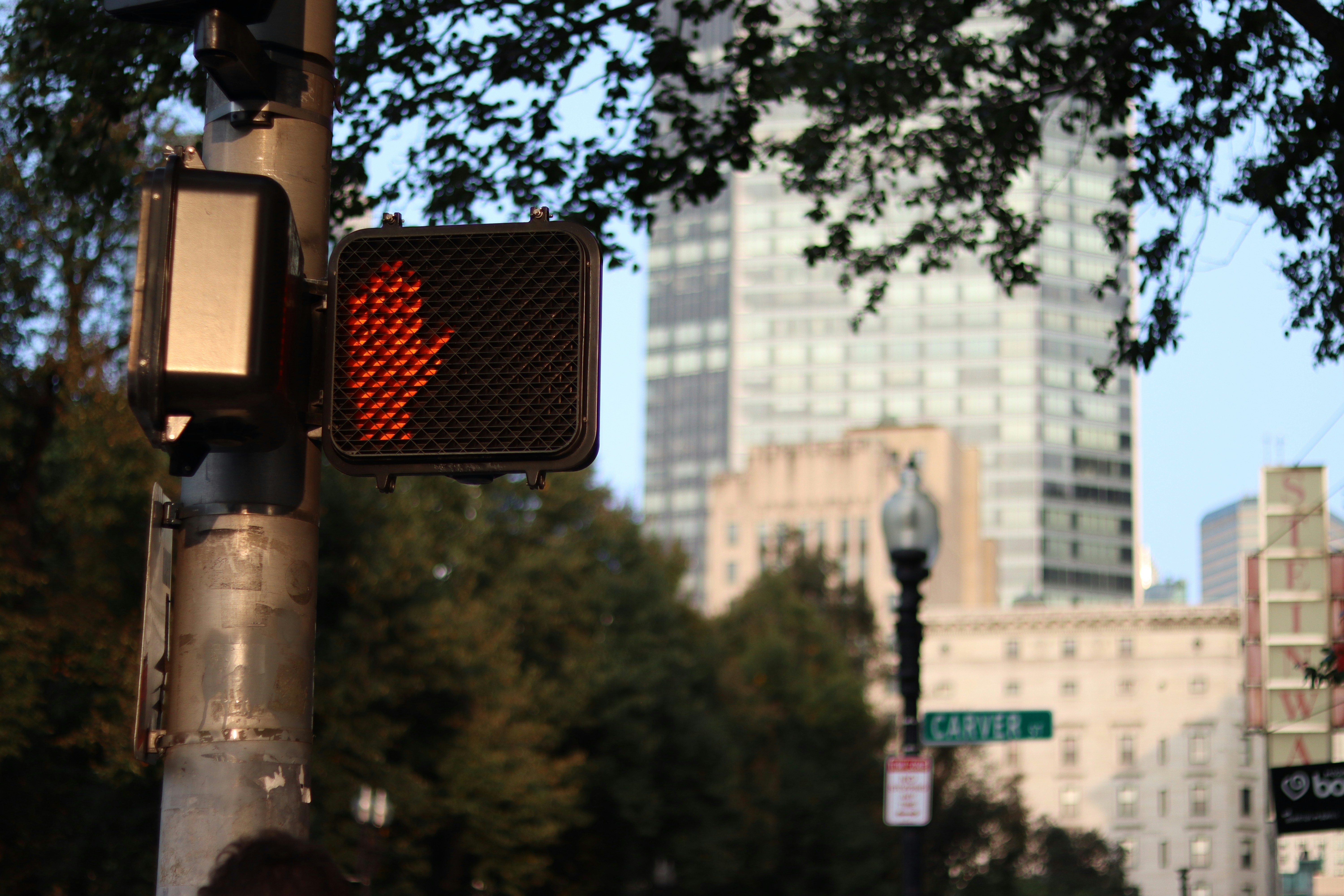 A traffic light on a city street with tall buildings in the background