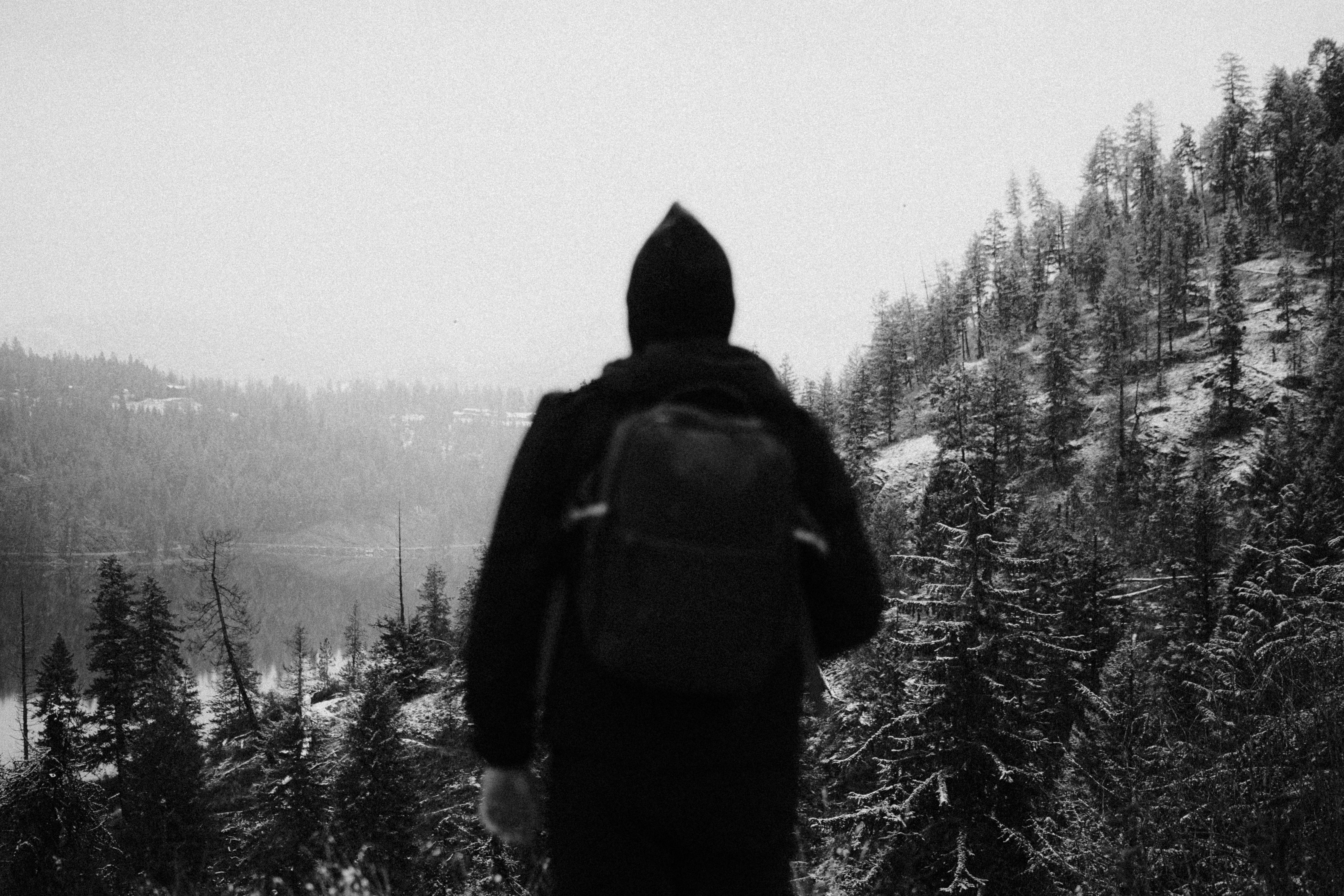 A person with a backpack standing on a snowy hill
