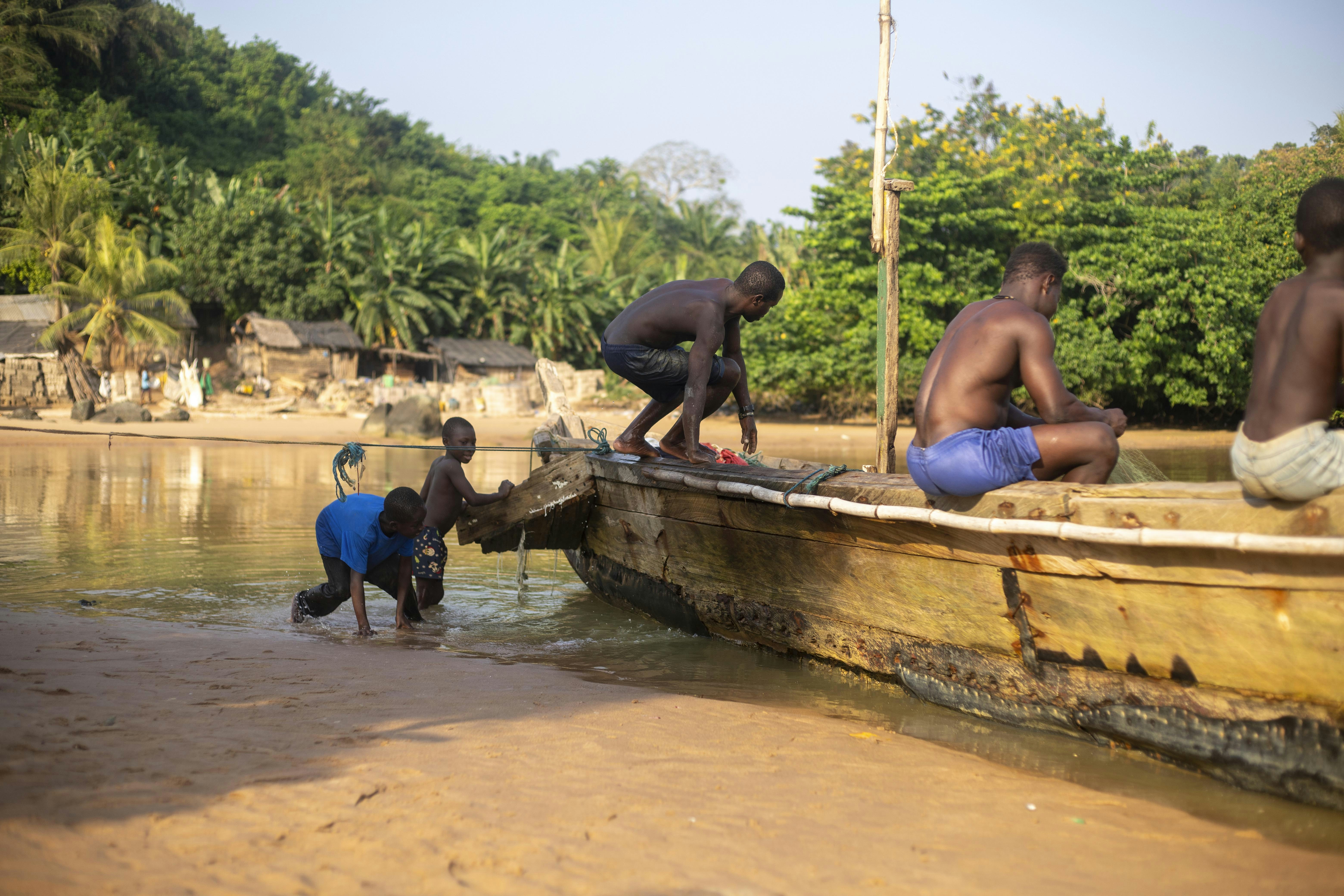 A group of men standing on top of a boat
