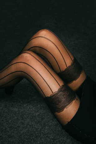 A woman in stockings and stockings laying on the floor