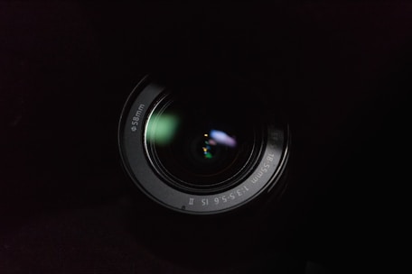 A close up of a camera lens in the dark