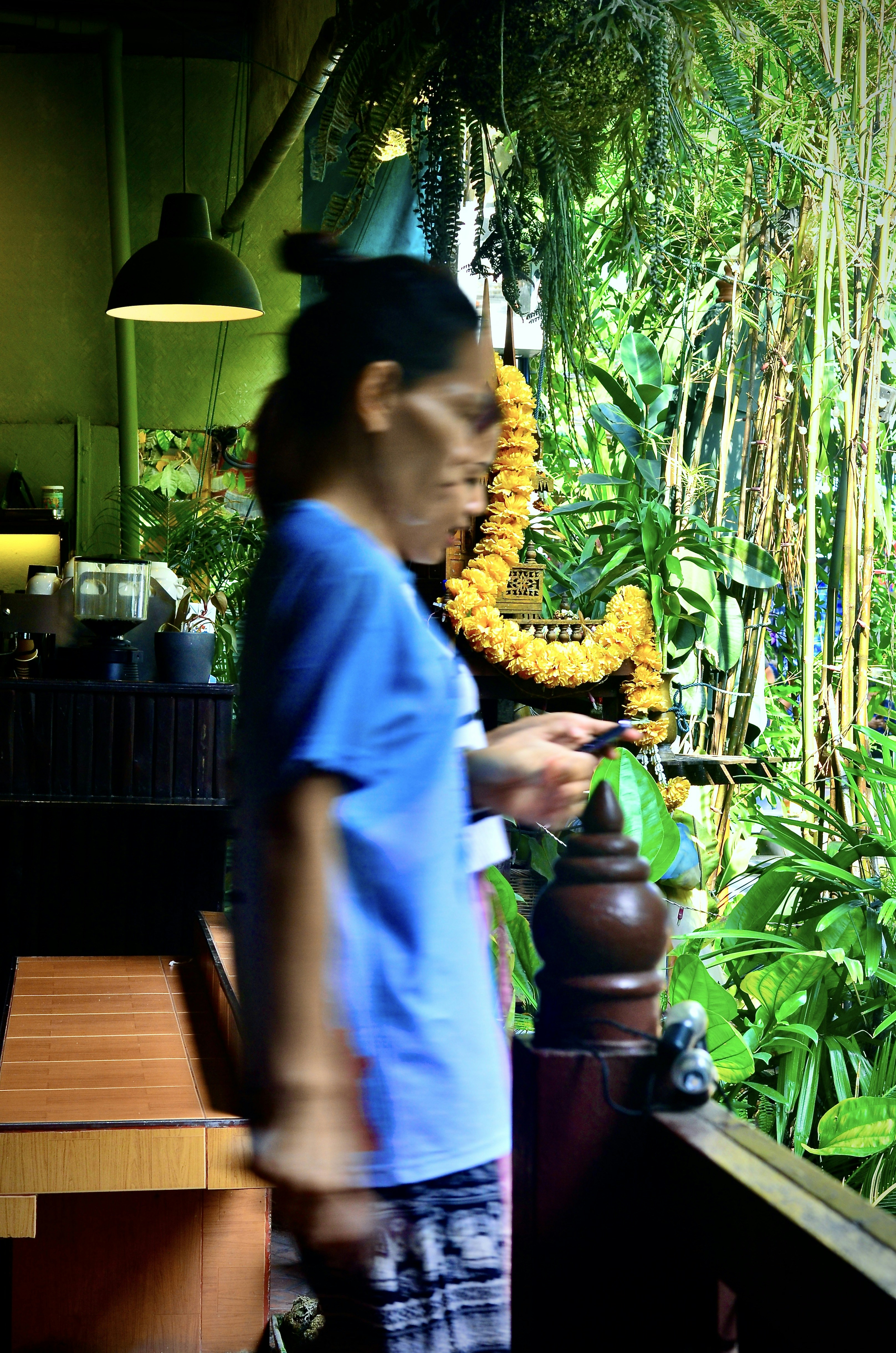 A woman standing in front of a window looking at a cell phone