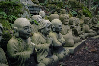 A row of statues of buddhas sitting in a forest