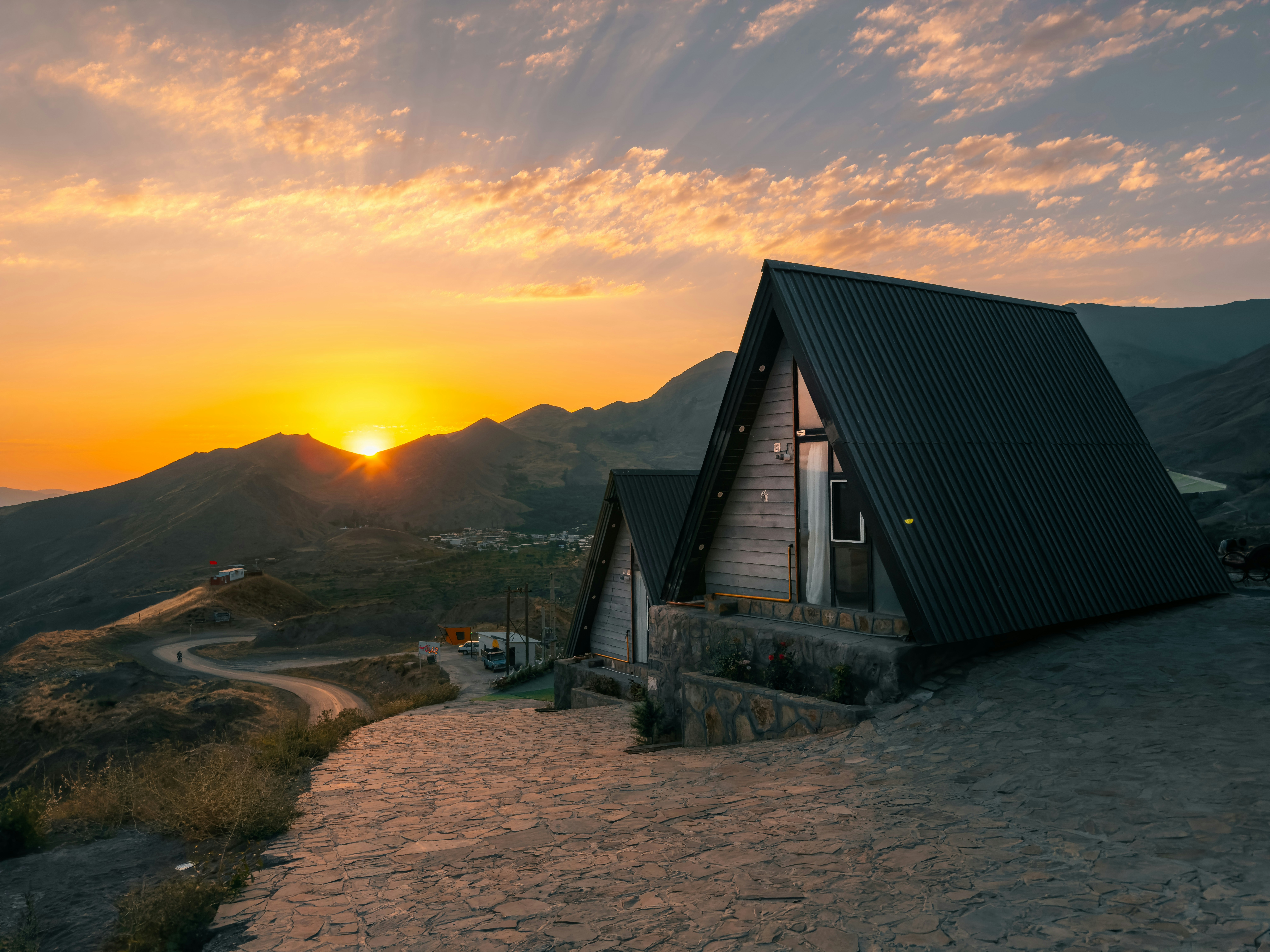 The sun is setting over a small cabin