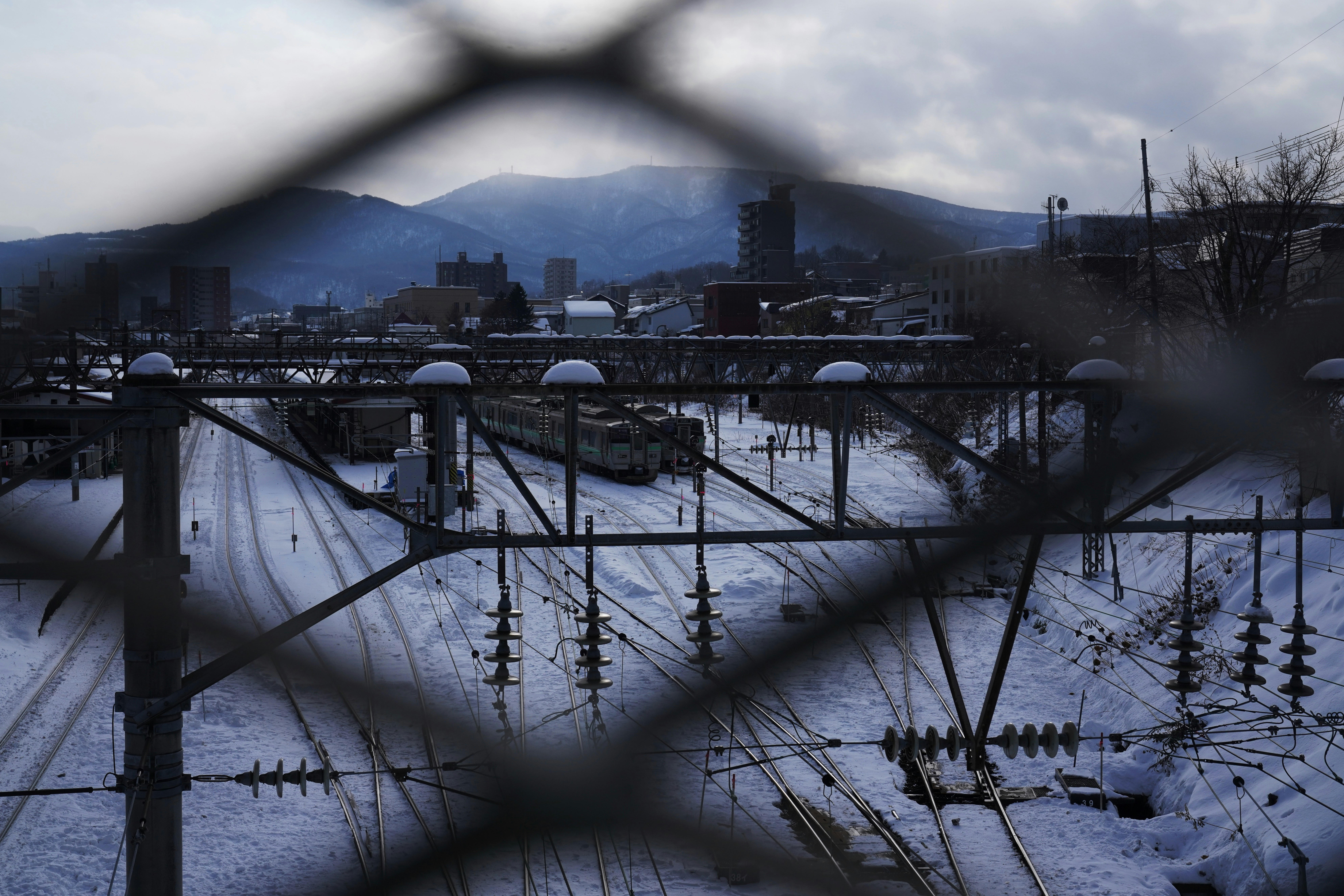 A view of a train yard through a chain link fence