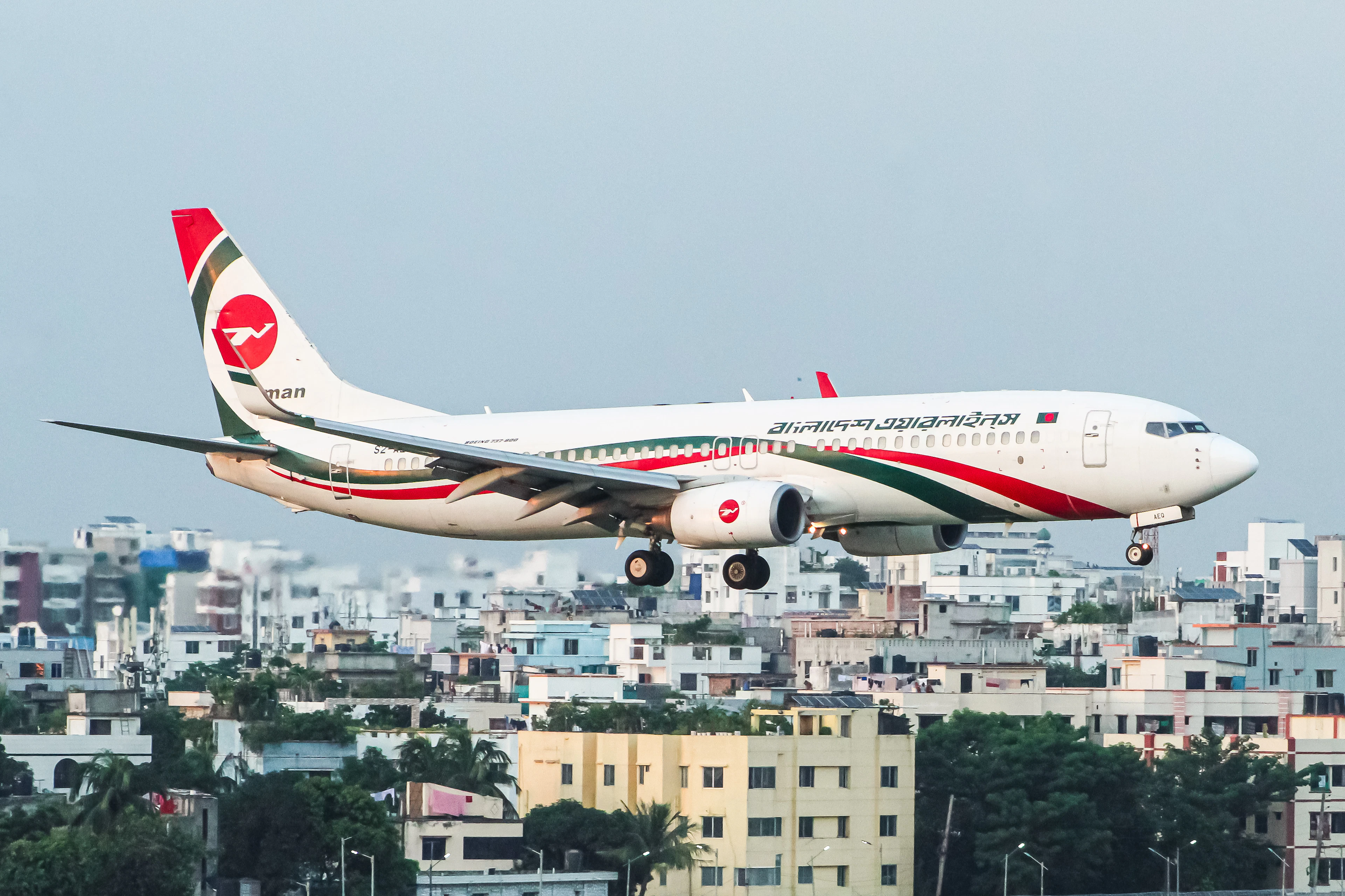 Passenger jet coming in to land low over a city