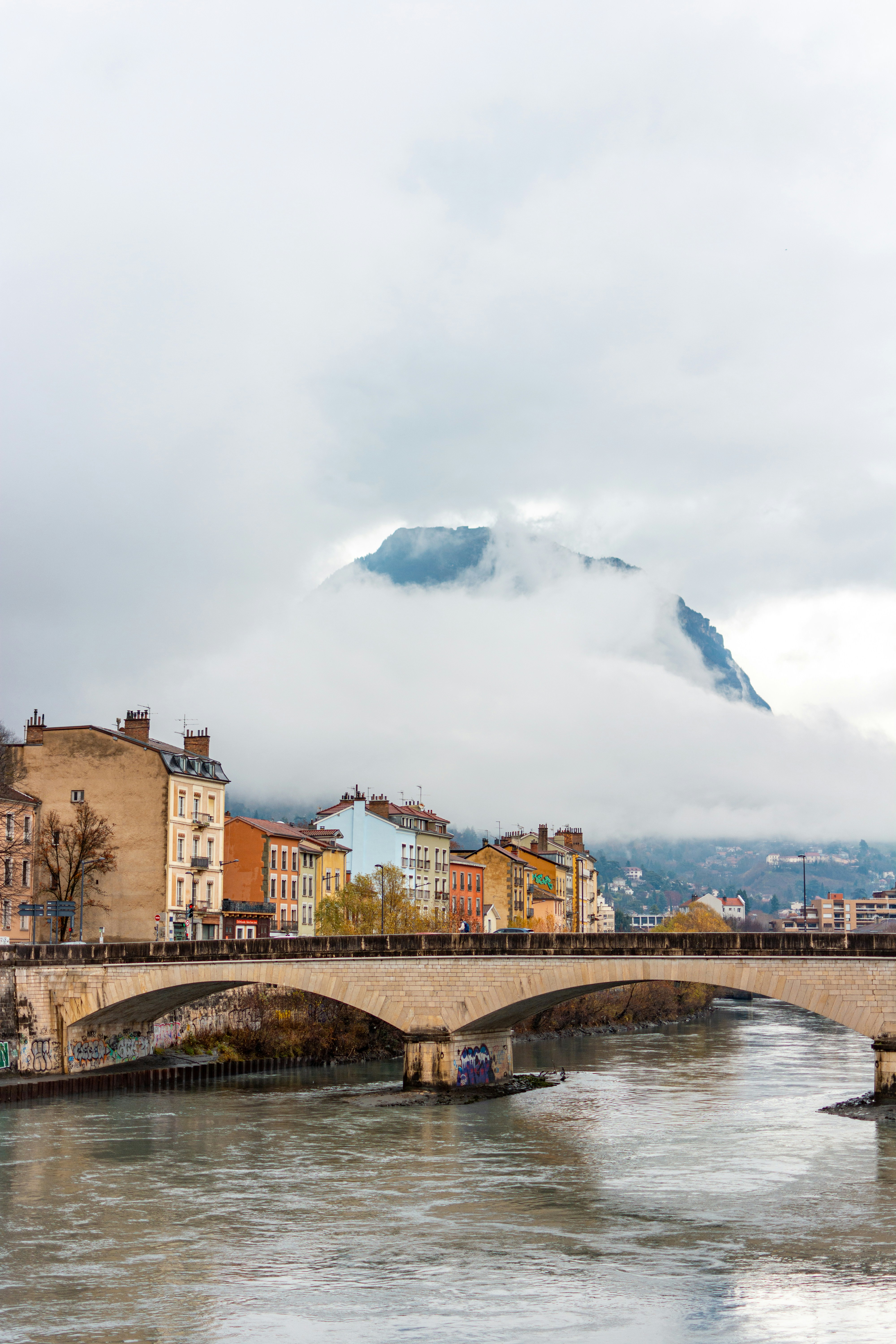 A bridge over a river with a mountain in the background