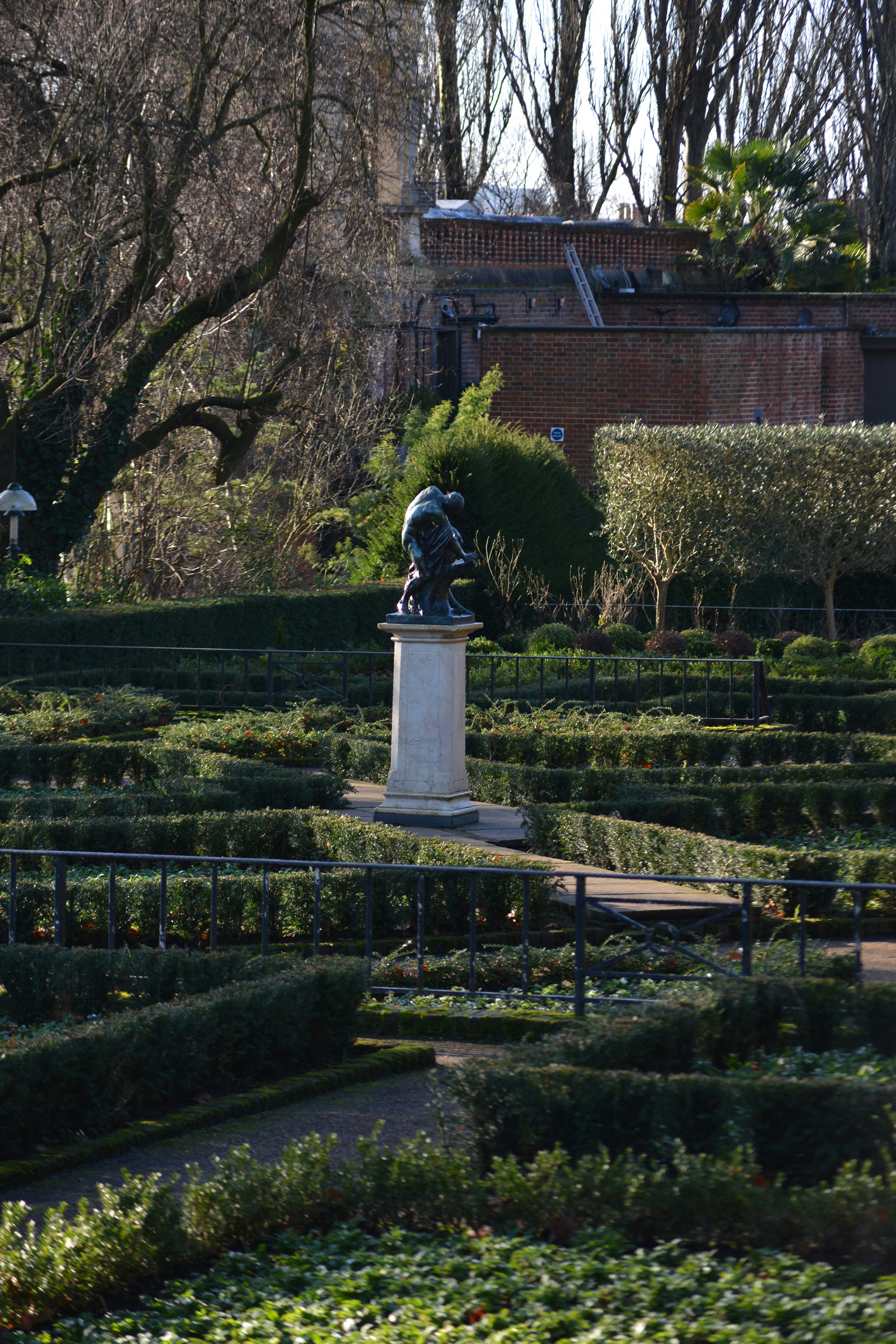 Un jardín con una estatua en el centro