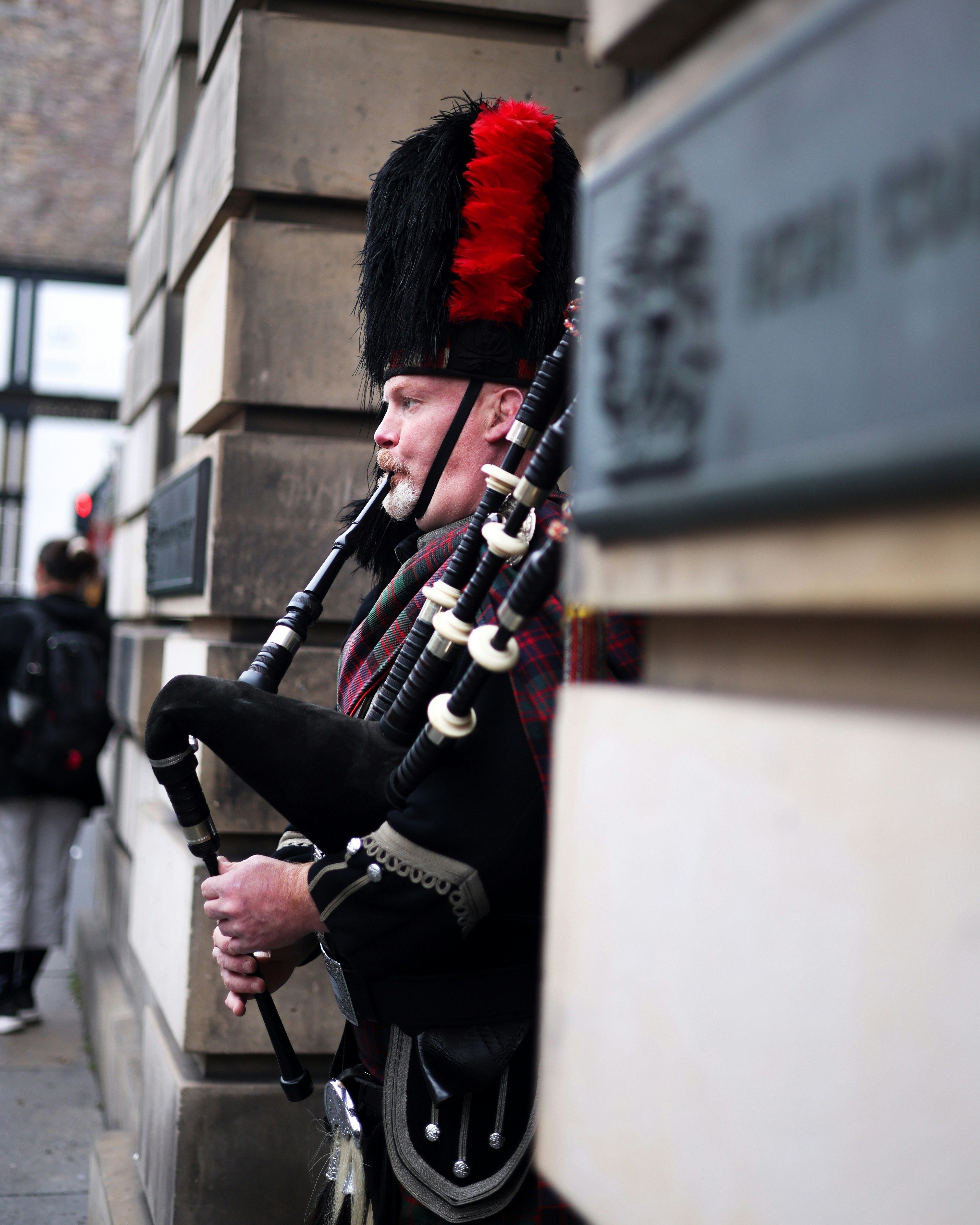 Ein Mann, der vor einem Gebäude Dudelsack spielt