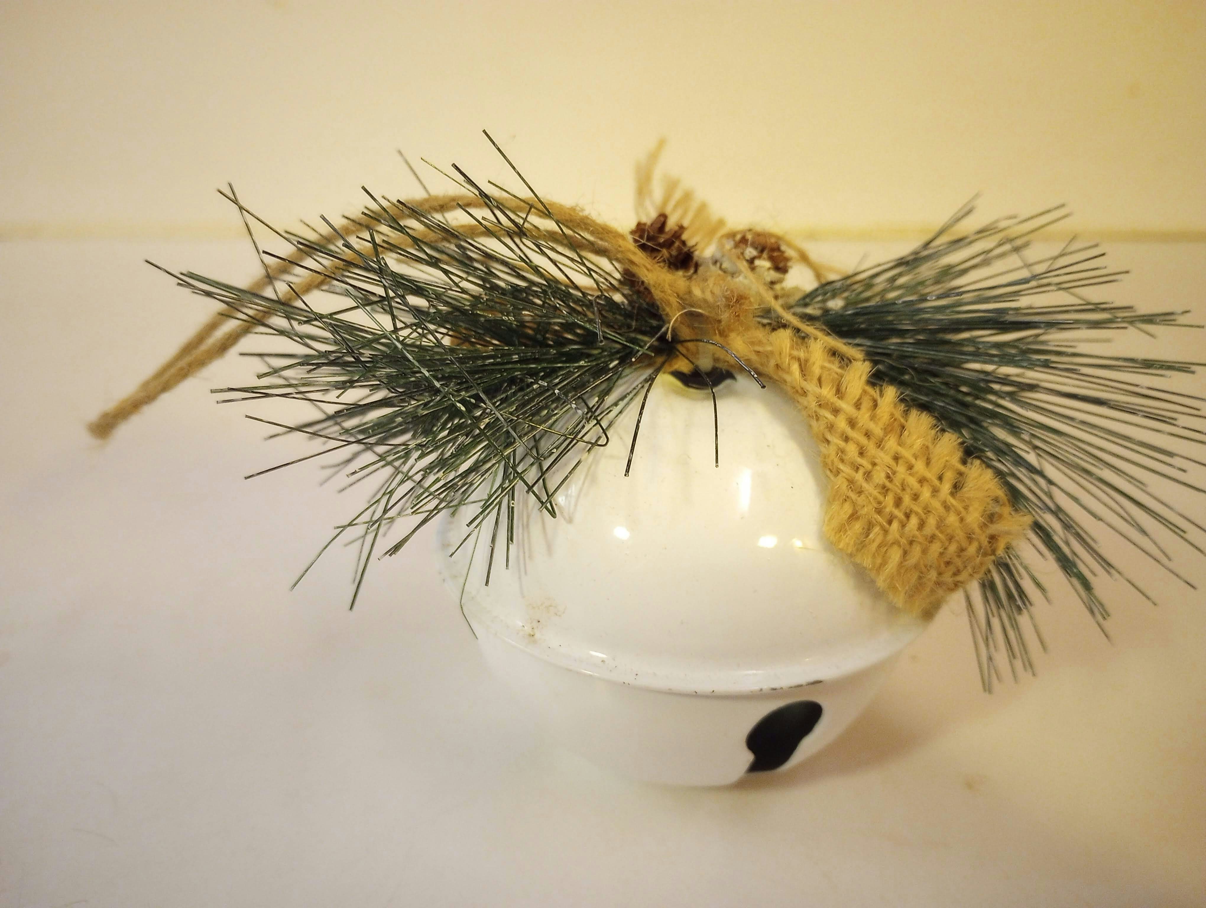 A white vase with a plant in it