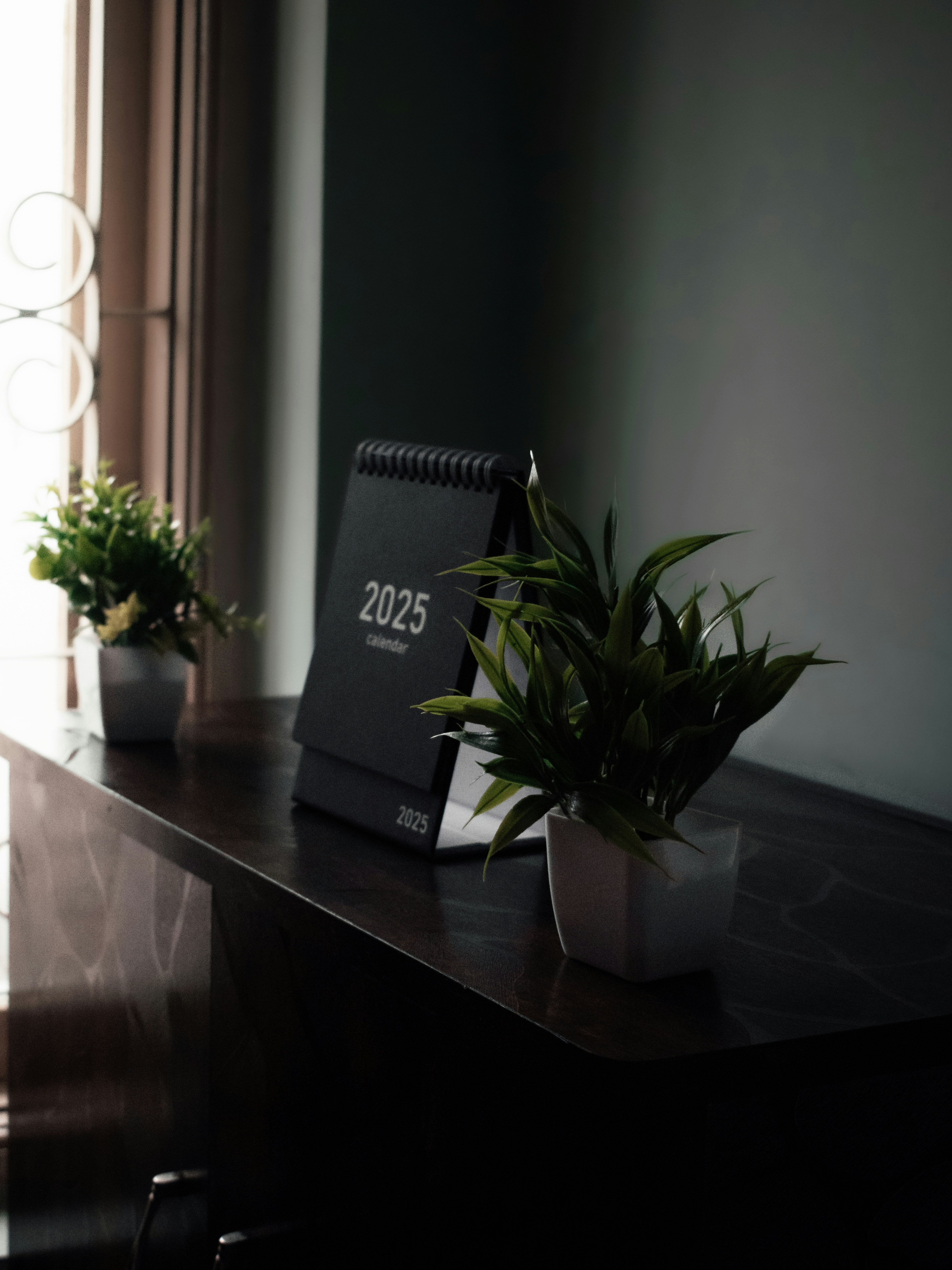 A desk with a clock and a plant on it