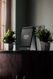 A desk with a calendar and plants on it