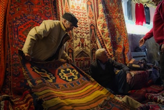A group of men standing around a pile of rugs