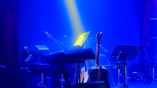 A stage with a piano, keyboard and other musical instruments