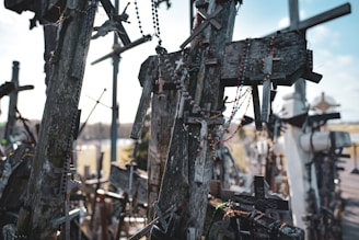 A bunch of wooden crosses hanging from the side of a road