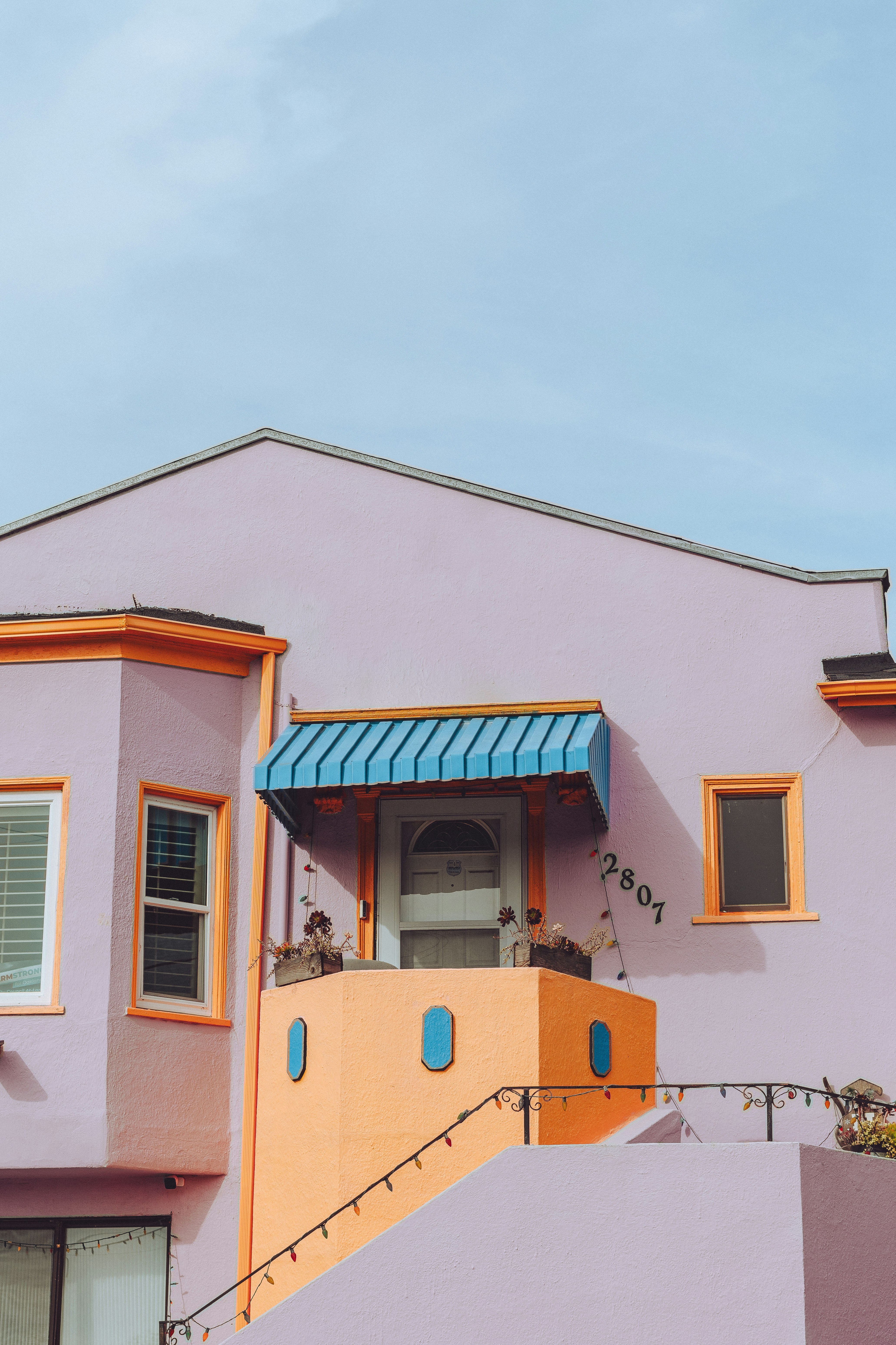 Una casa rosa con un toldo azul