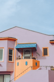 A pink house with a blue awning