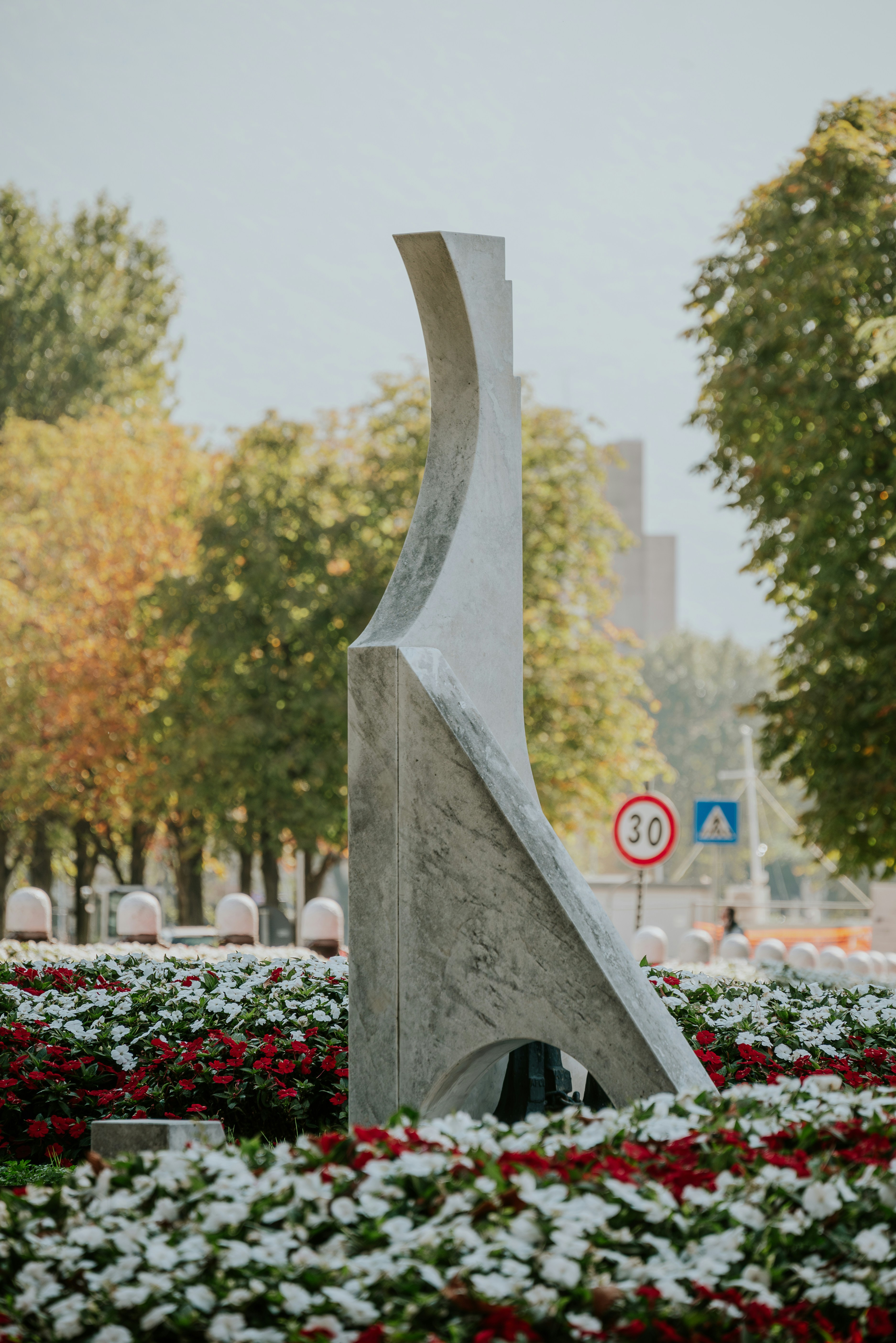 A sculpture in a park with flowers in the foreground