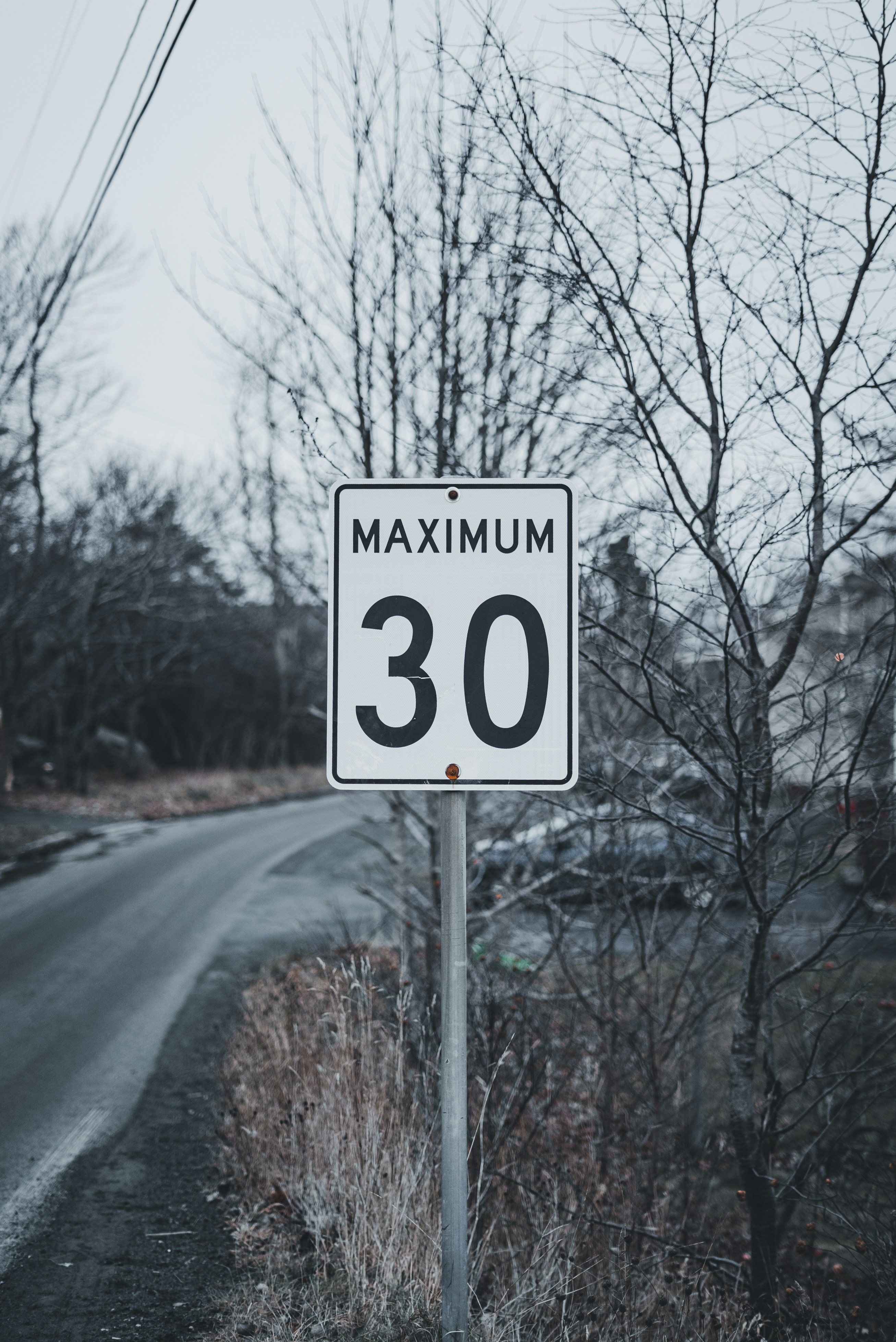 A speed limit sign sitting on the side of a road