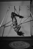 A woman hanging upside down on a pole