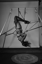 A woman hanging upside down on a pole