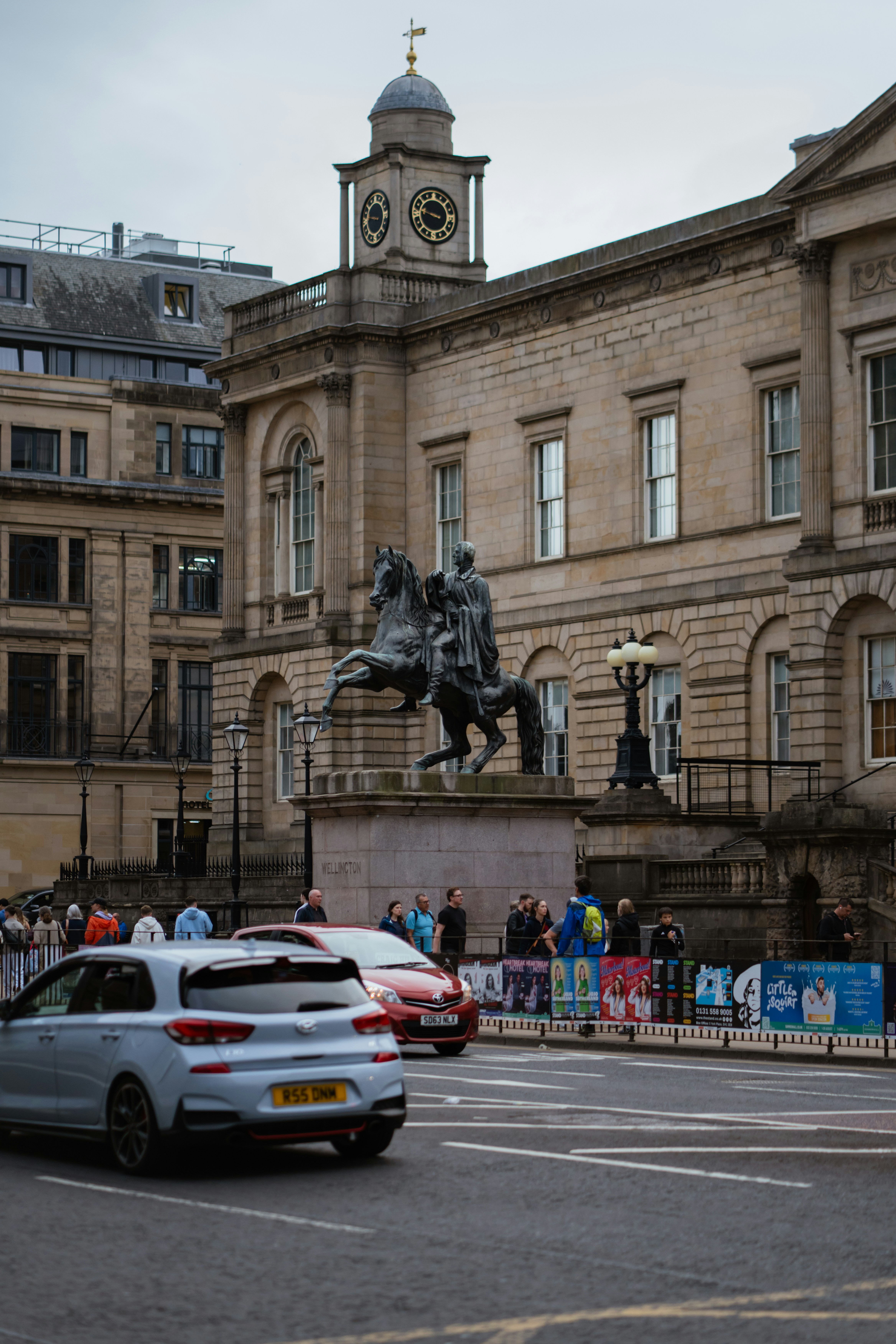 A car driving down a street next to a tall building