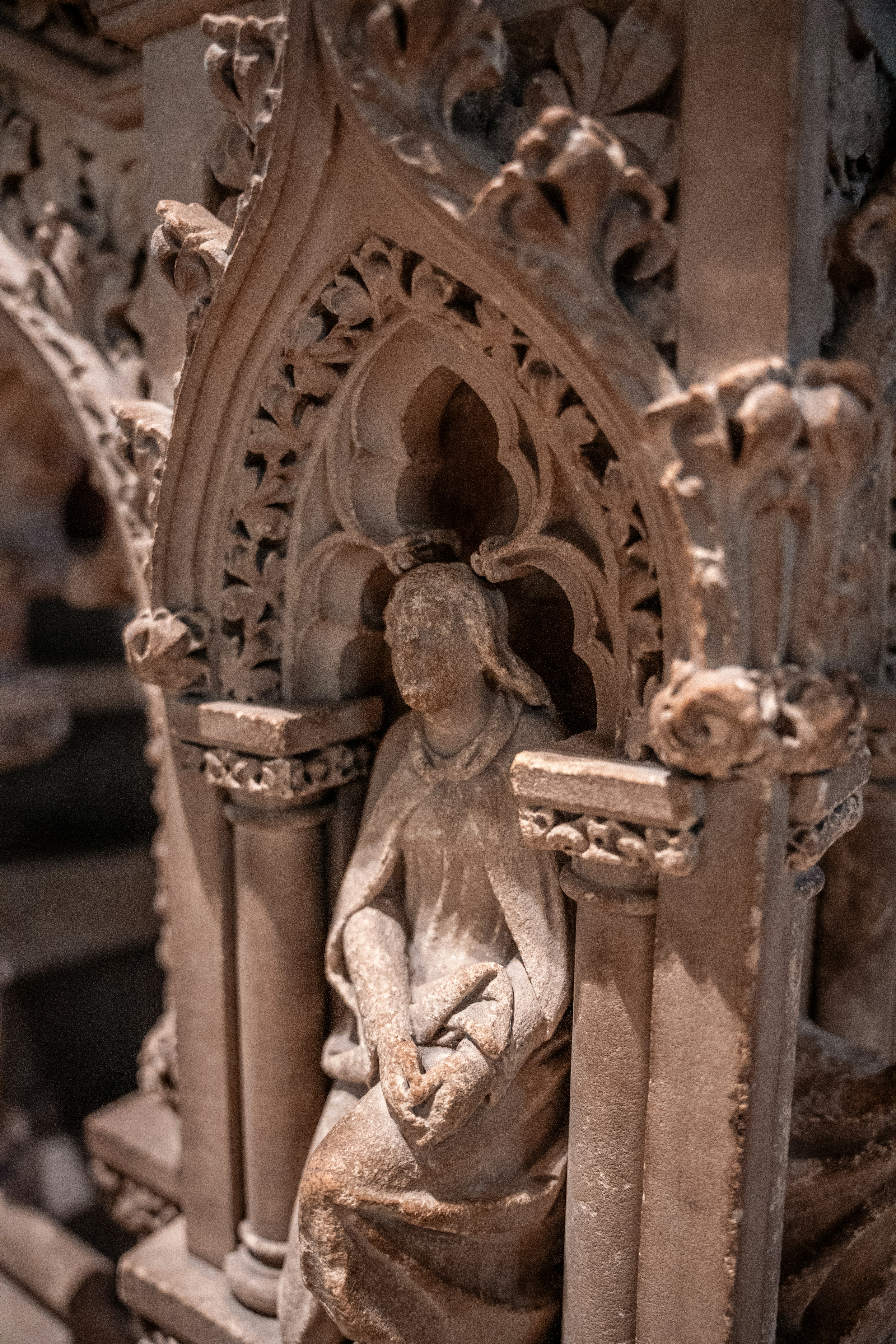 A statue of a woman sitting on a pillar