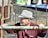 A man in a hat leaning on a fence
