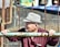 A man in a hat leaning on a fence