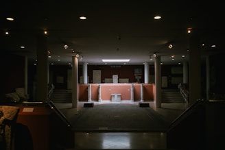 A dimly lit room with stairs leading up to a podium