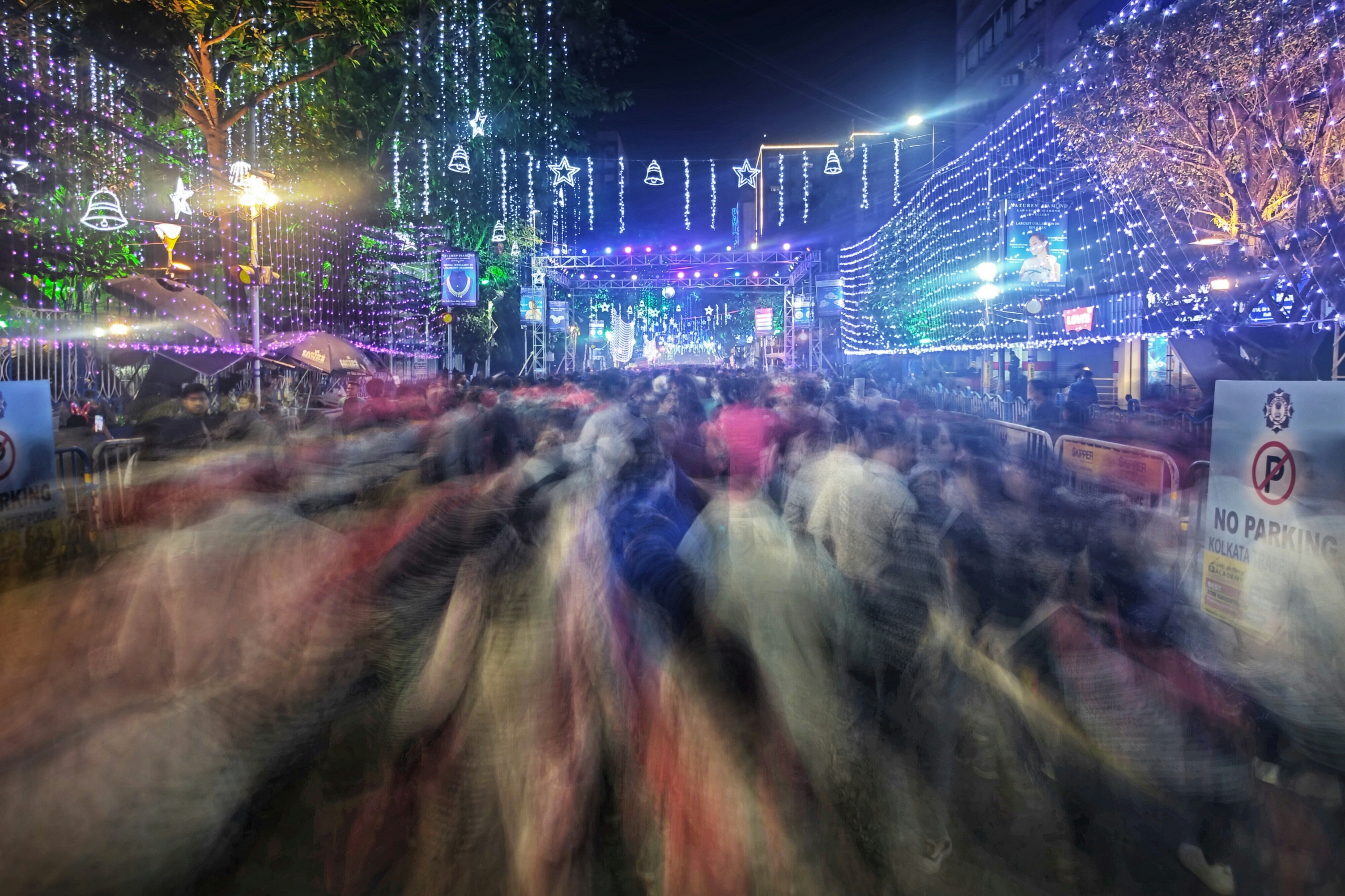 A crowd of people walking down a street at night
