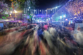 A crowd of people walking down a street at night