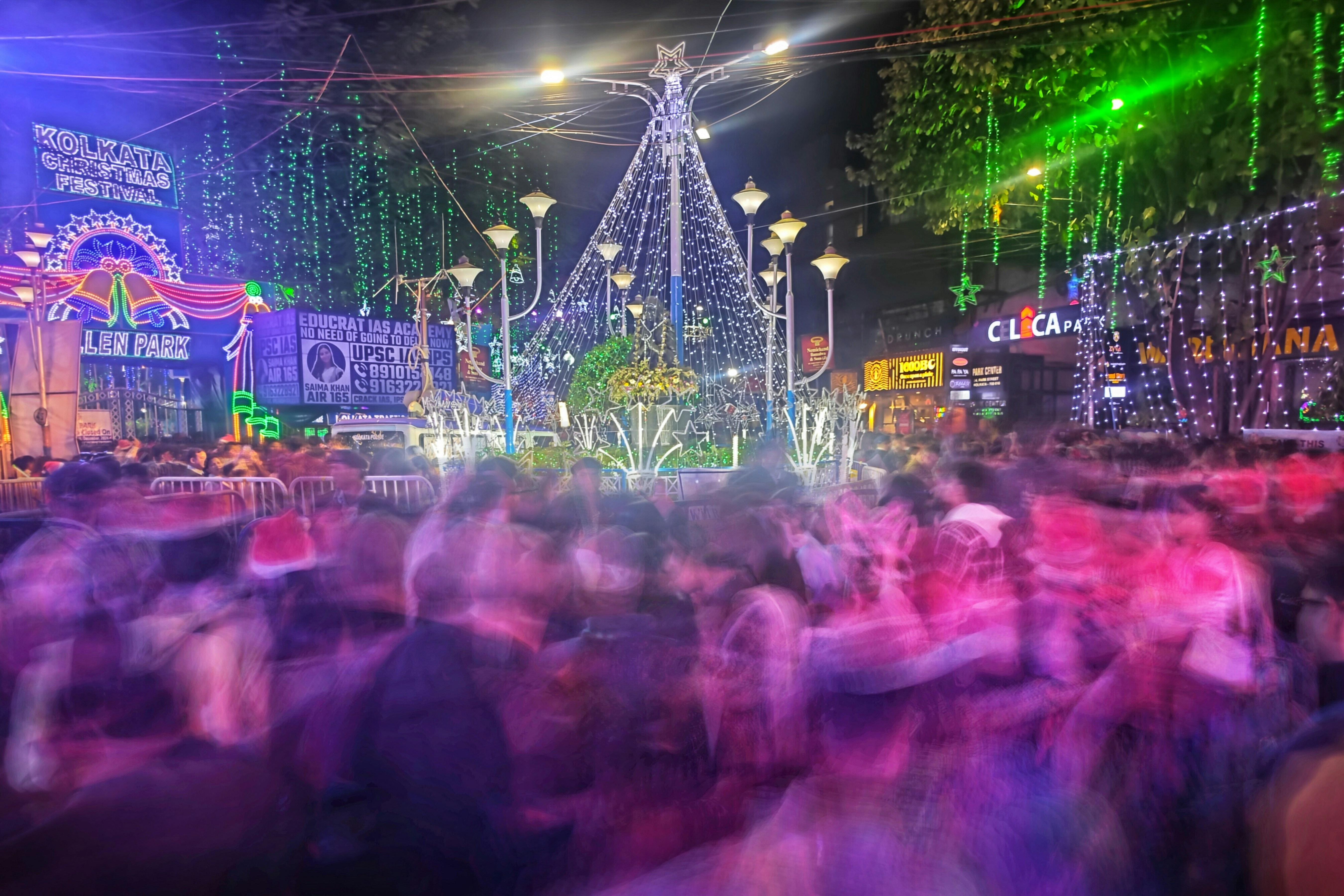 A crowd of people standing around a christmas tree