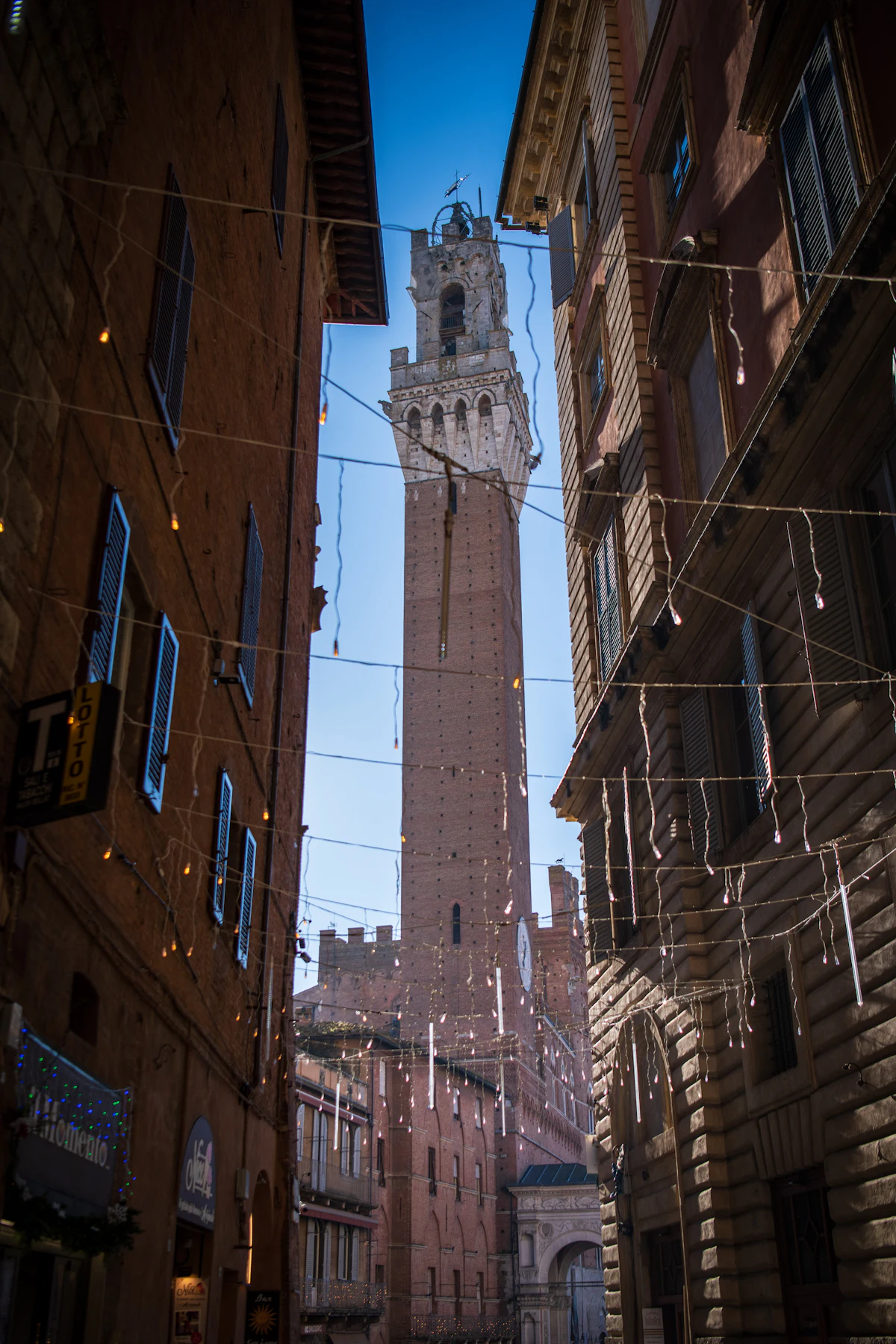 The Torre del Mangia seen up a narrow street in Siena