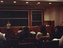 A group of people sitting in front of a blackboard