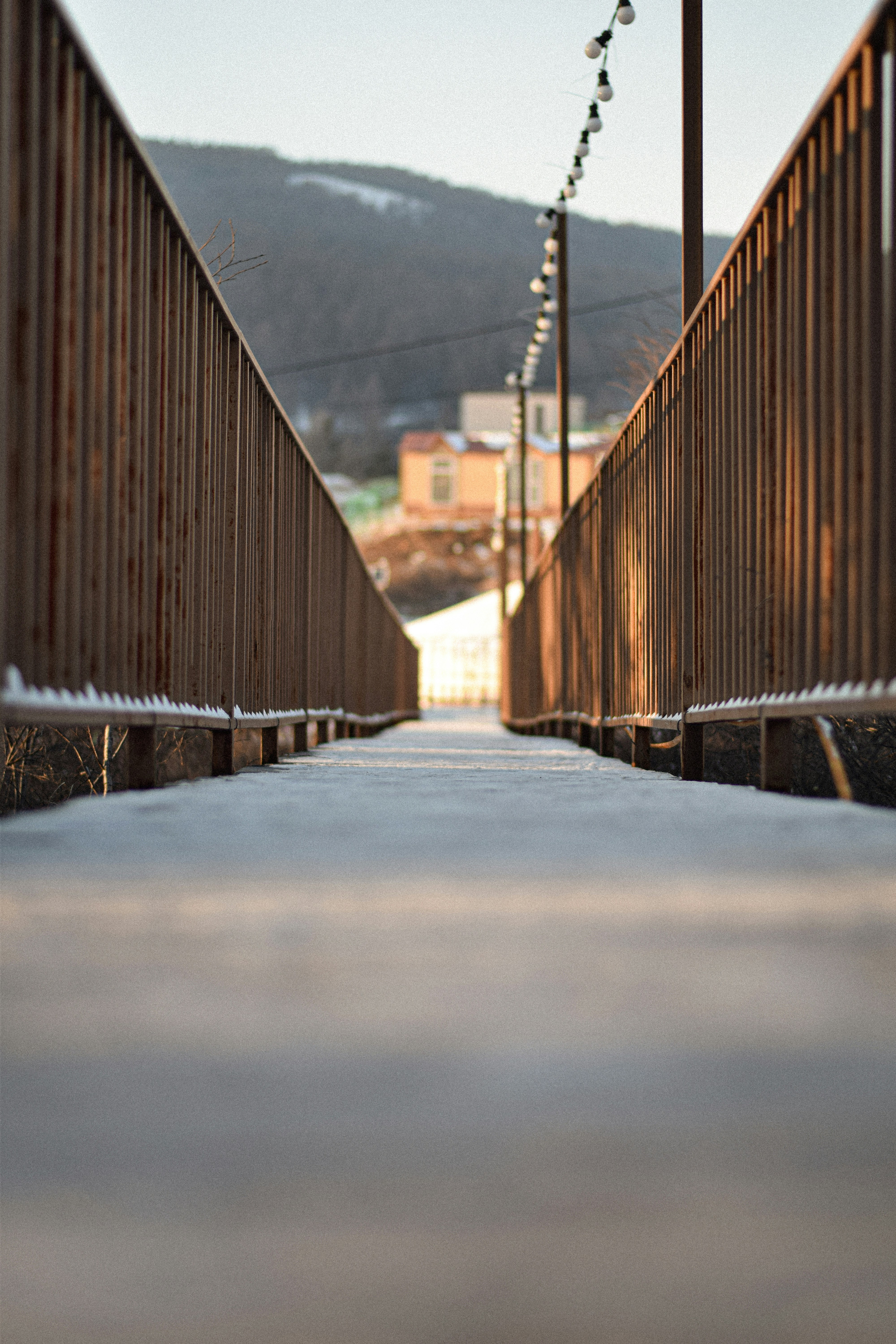 A long walkway with a fence and a mountain in the background
