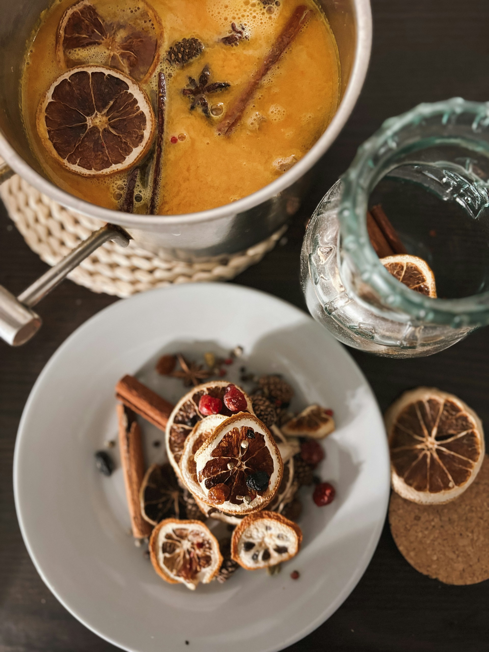 A bowl of soup with orange slices and cinnamons