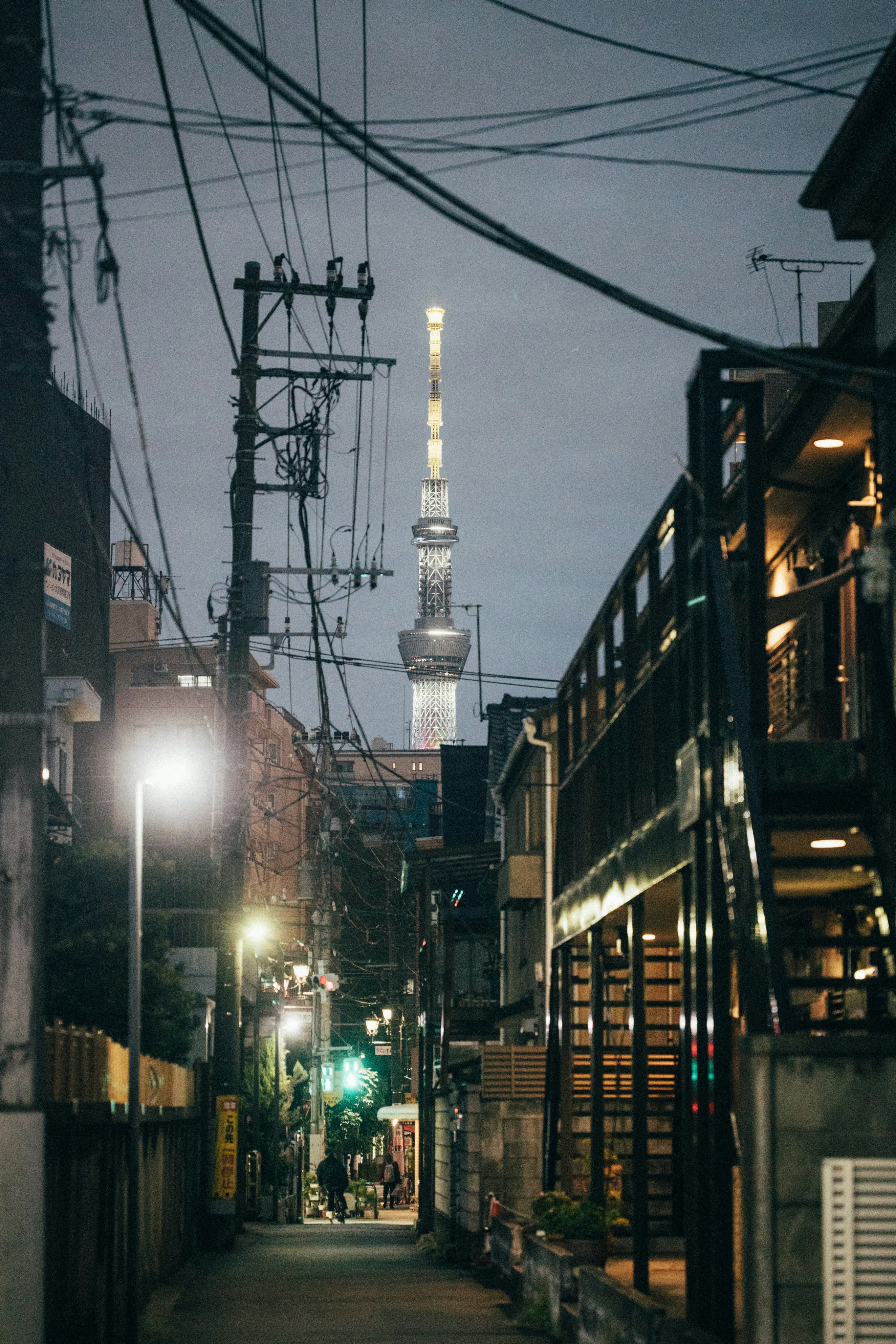 A city street at night with a tall building in the background