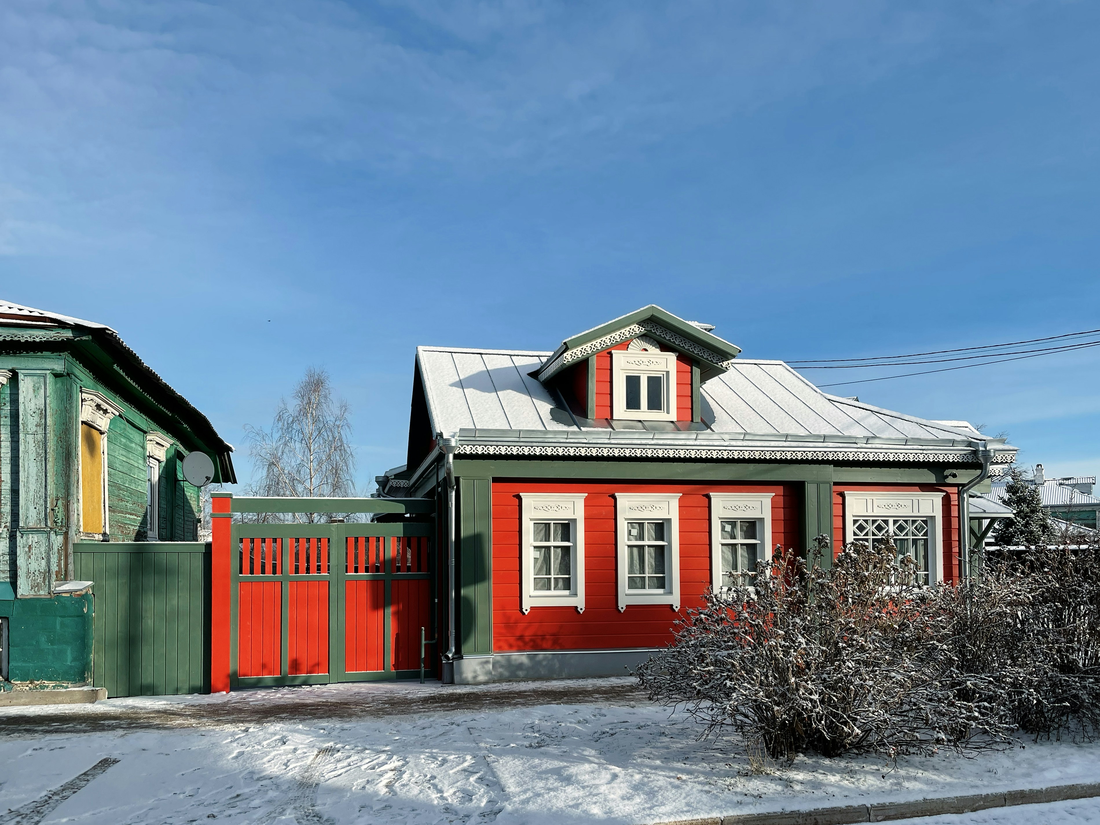 A red and green house in the snow