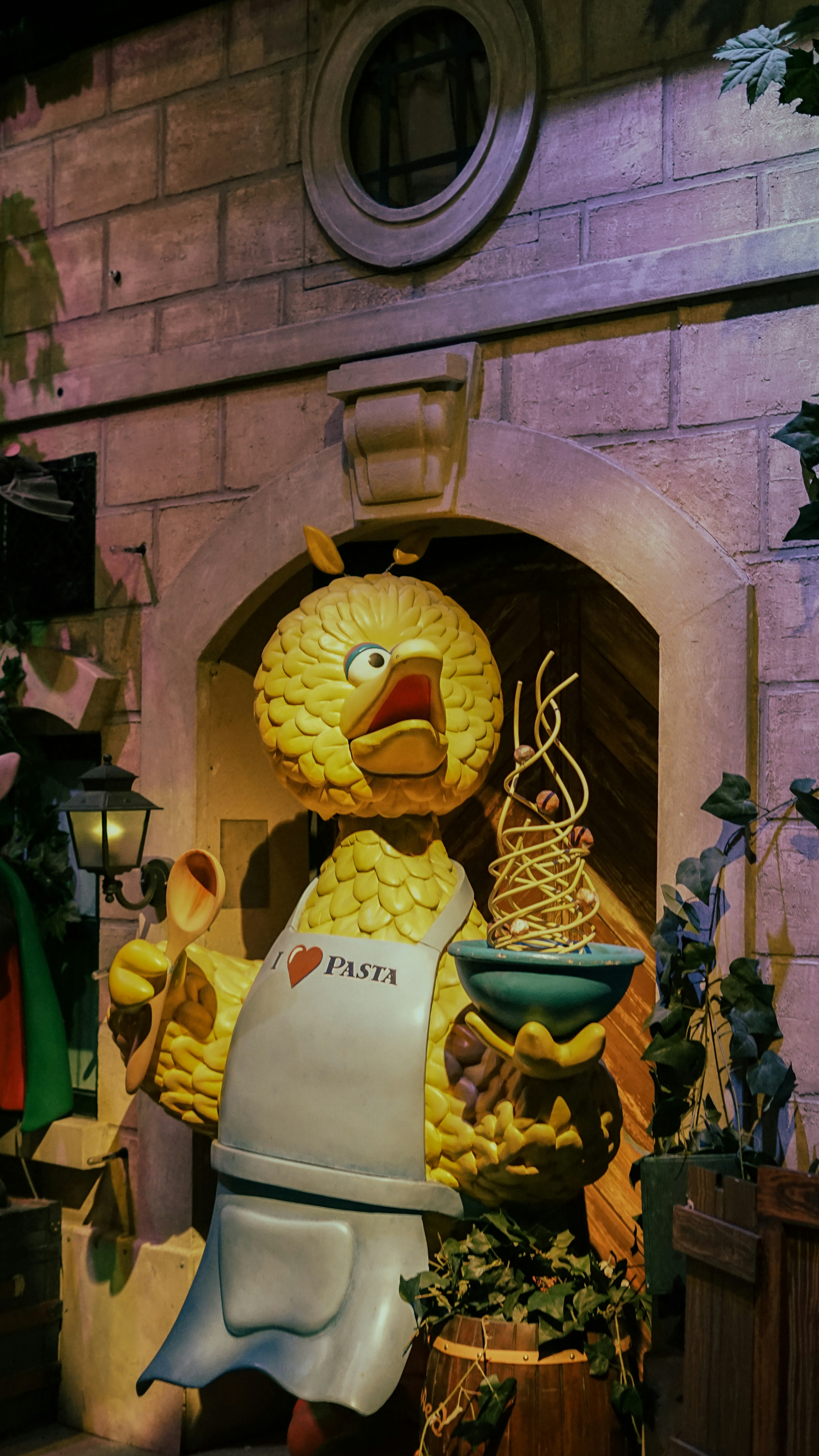 Una statua di un pollo che tiene in mano una ciotola di noodles