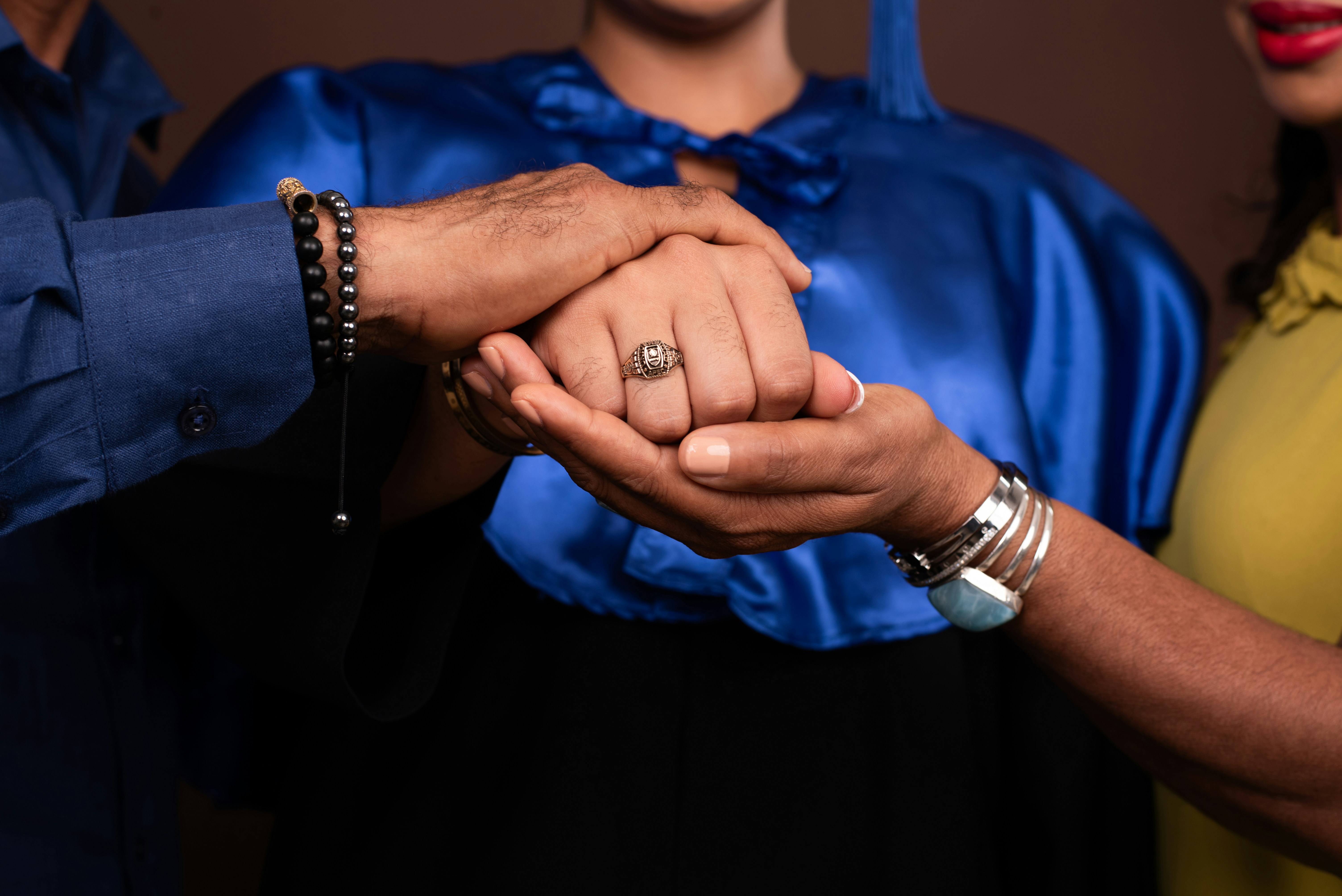 A man and woman holding hands in front of a brown background