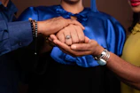 A man and woman holding hands in front of a brown background