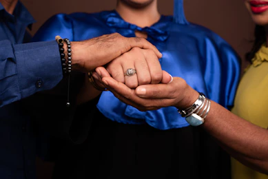A man and woman holding hands in front of a brown background