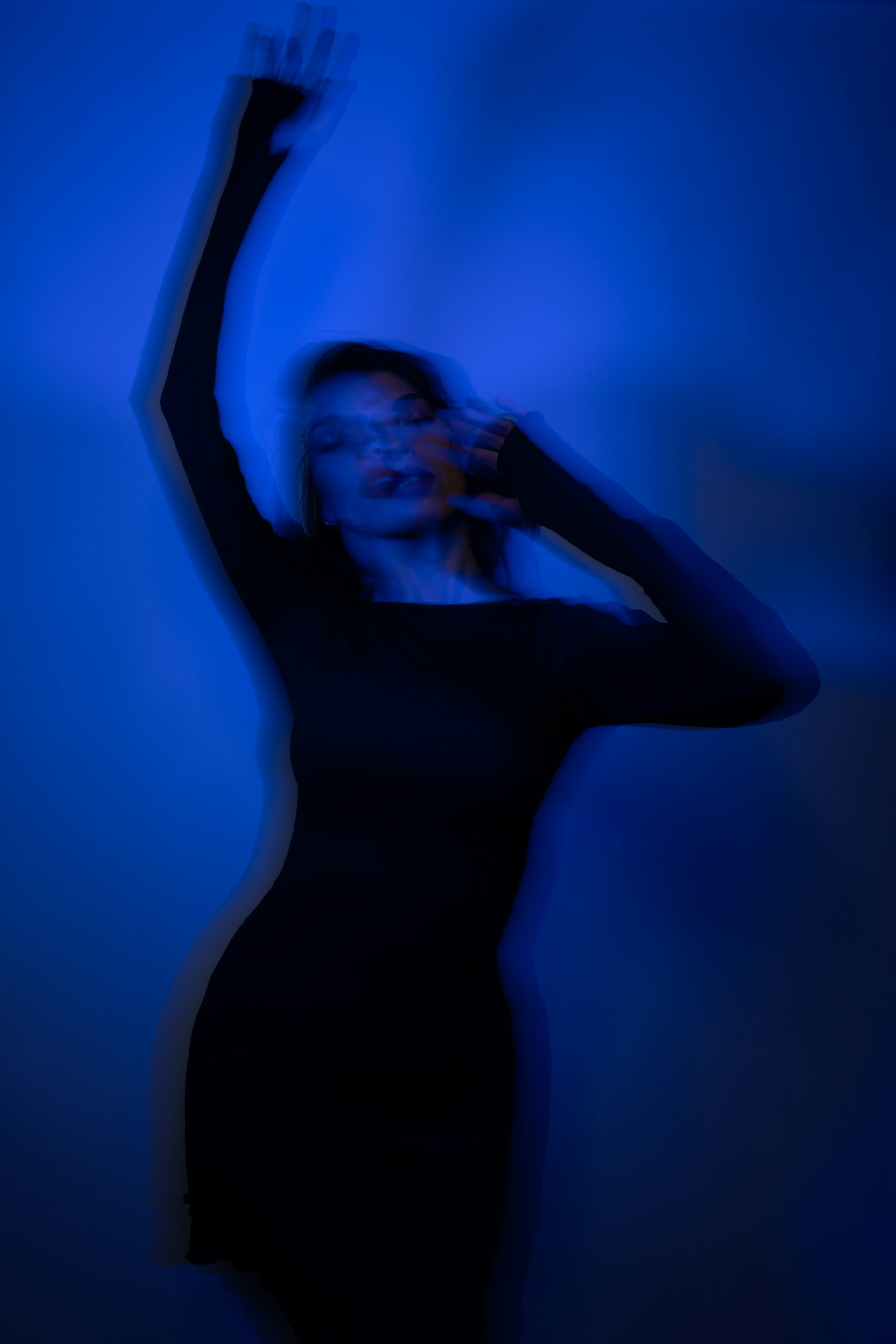 A woman in a black dress holding a cell phone