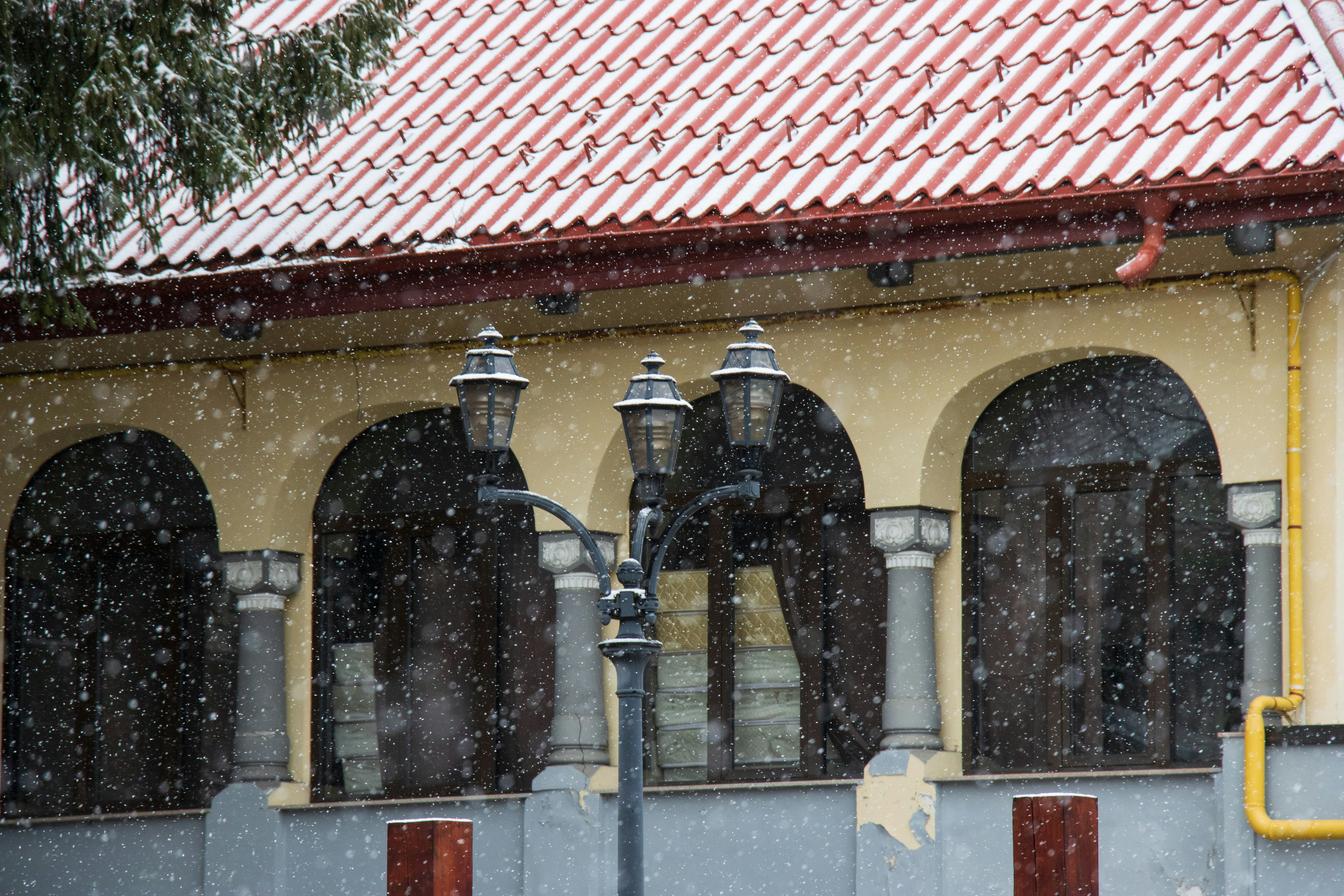 A yellow building with a red roof and a yellow fire hydrant