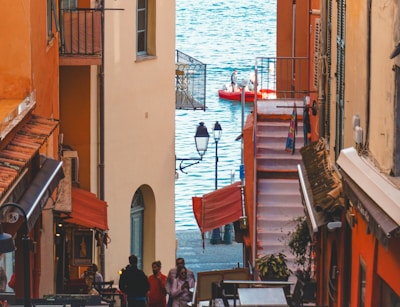 A group of people walking down a street next to a body of water