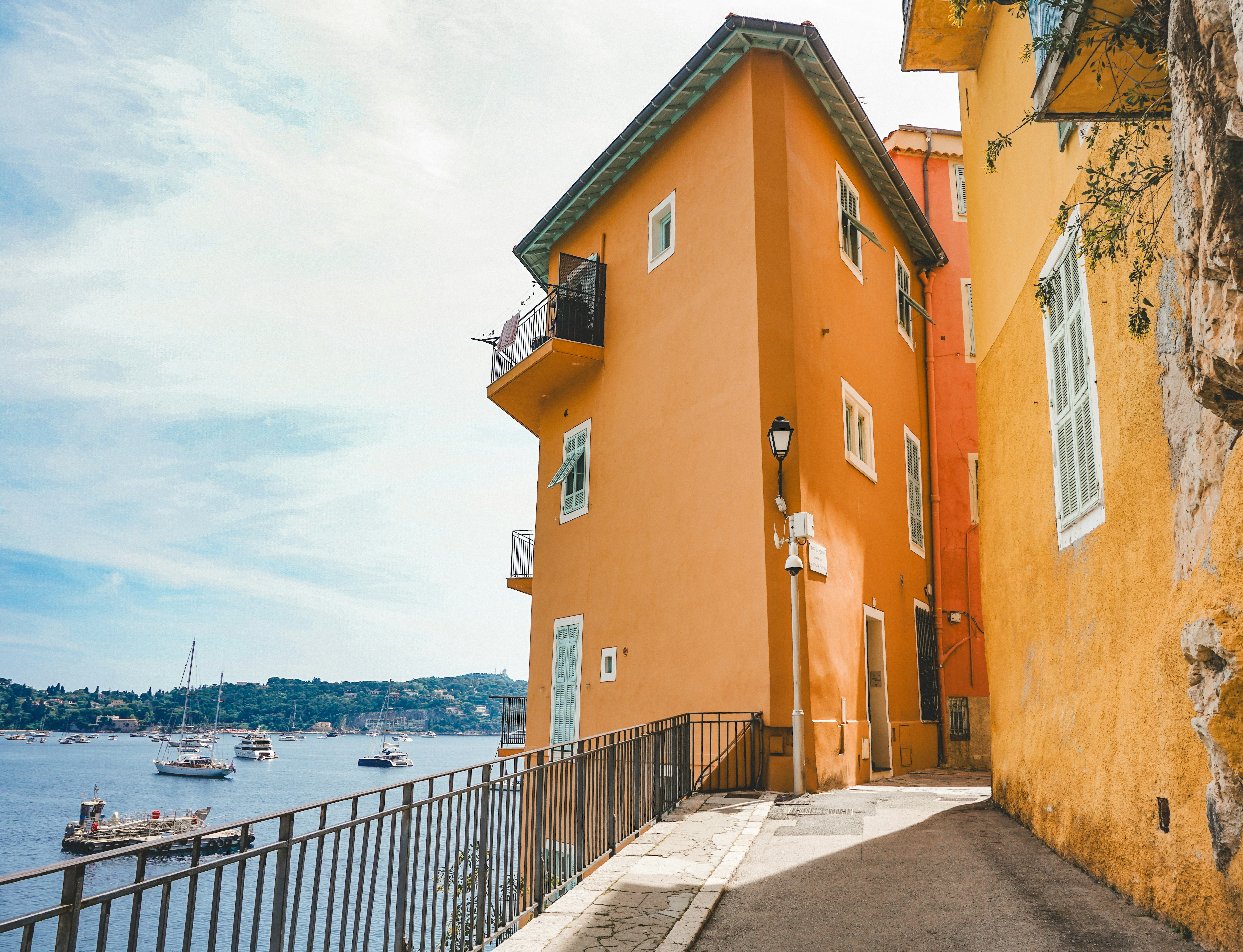 A yellow building on the side of a road next to a body of water