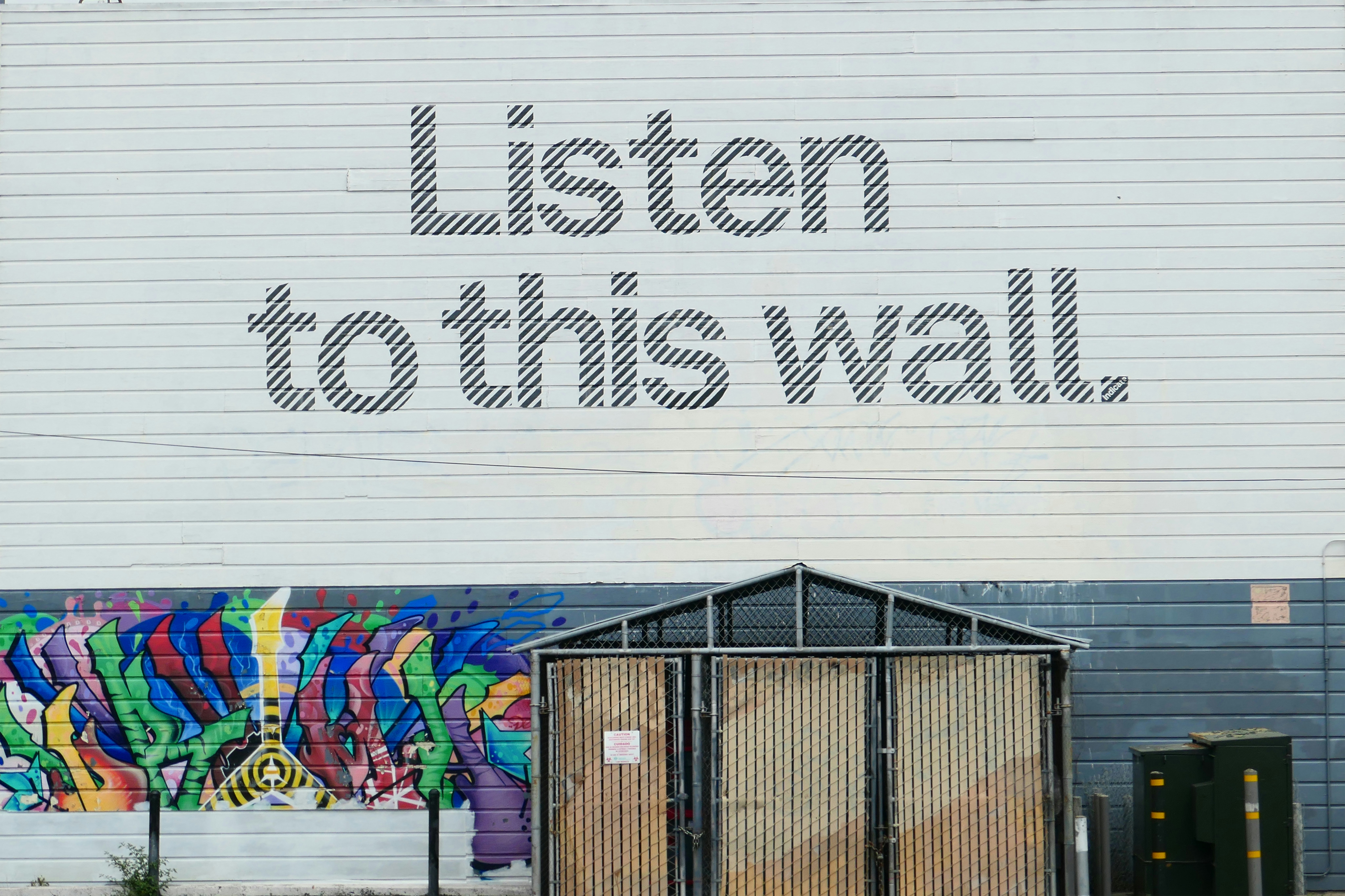 A sign that reads listen to this wall