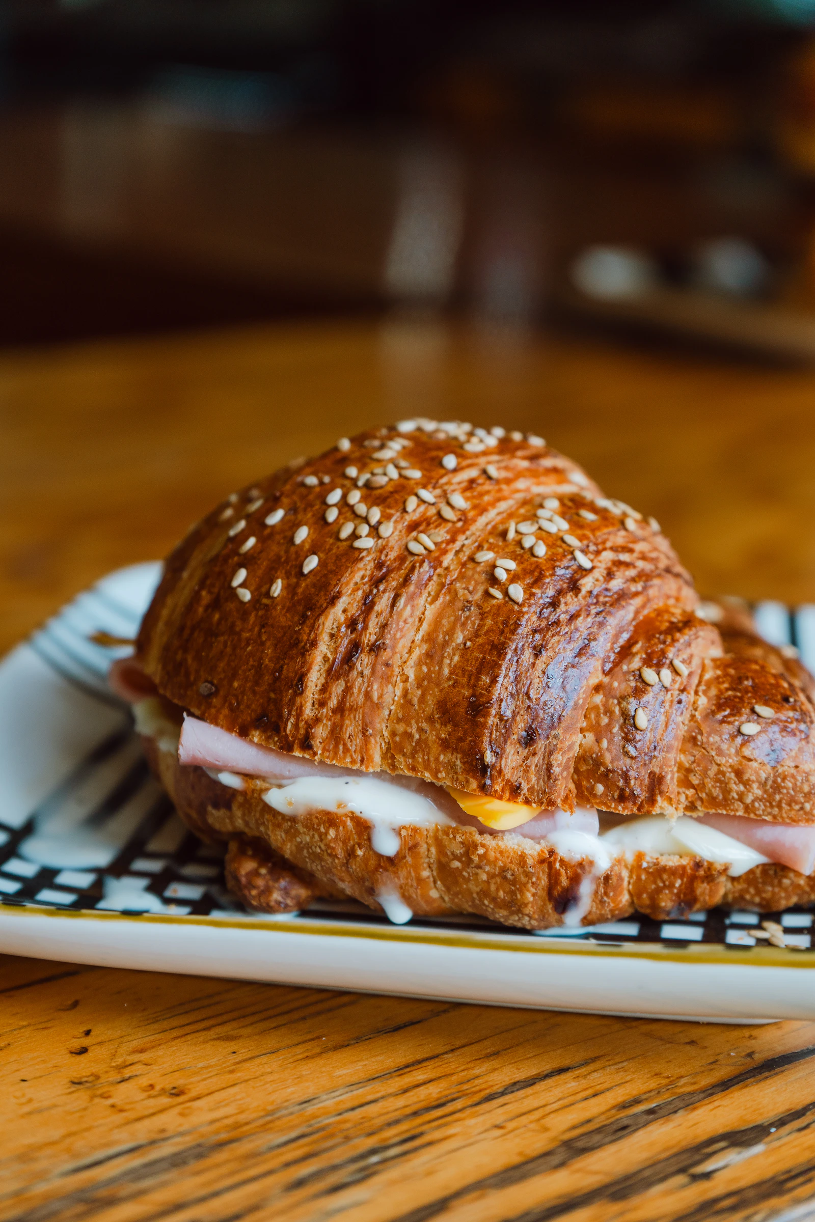 A ham and cheese croissant sandwich with melted cheese